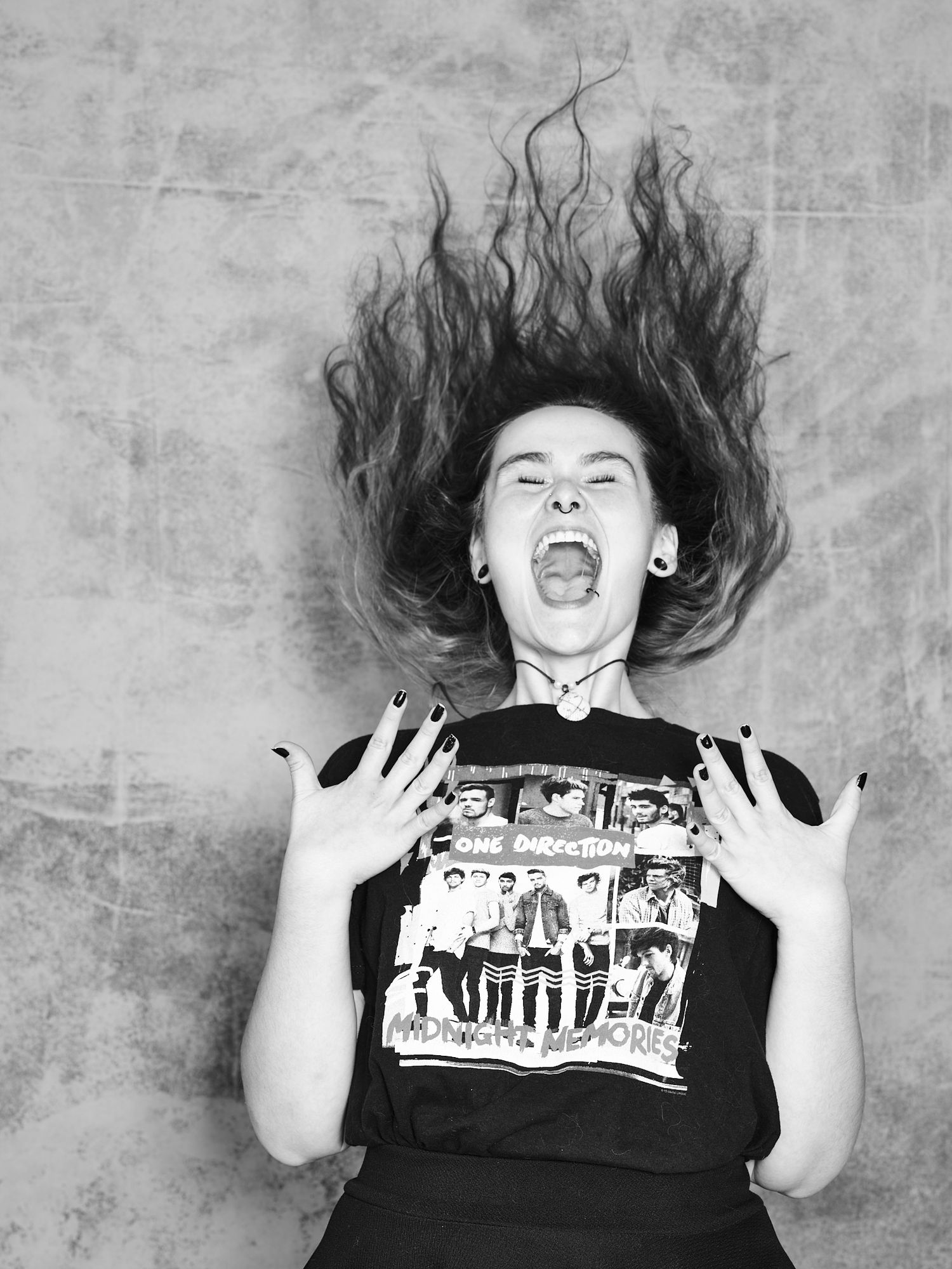 Dynamic shot of someone with hair flying while wearing a band t-shirt.