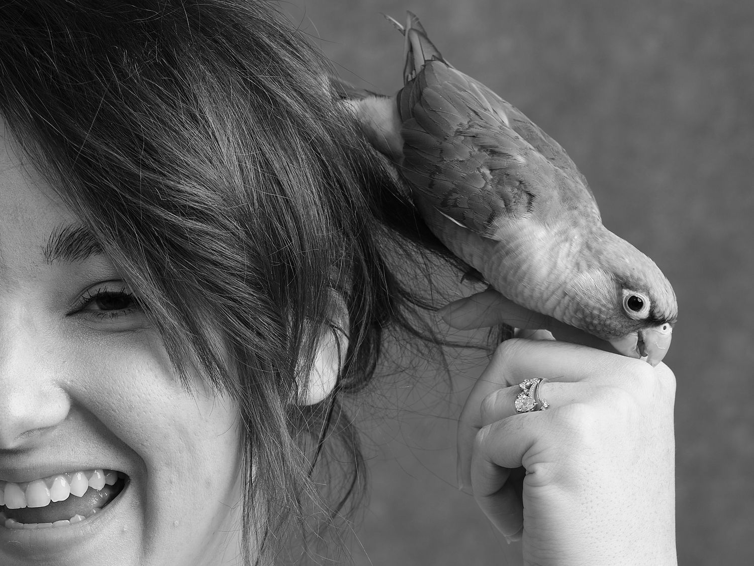 A charming candid moment captured with a friendly pet bird perched on a hand.