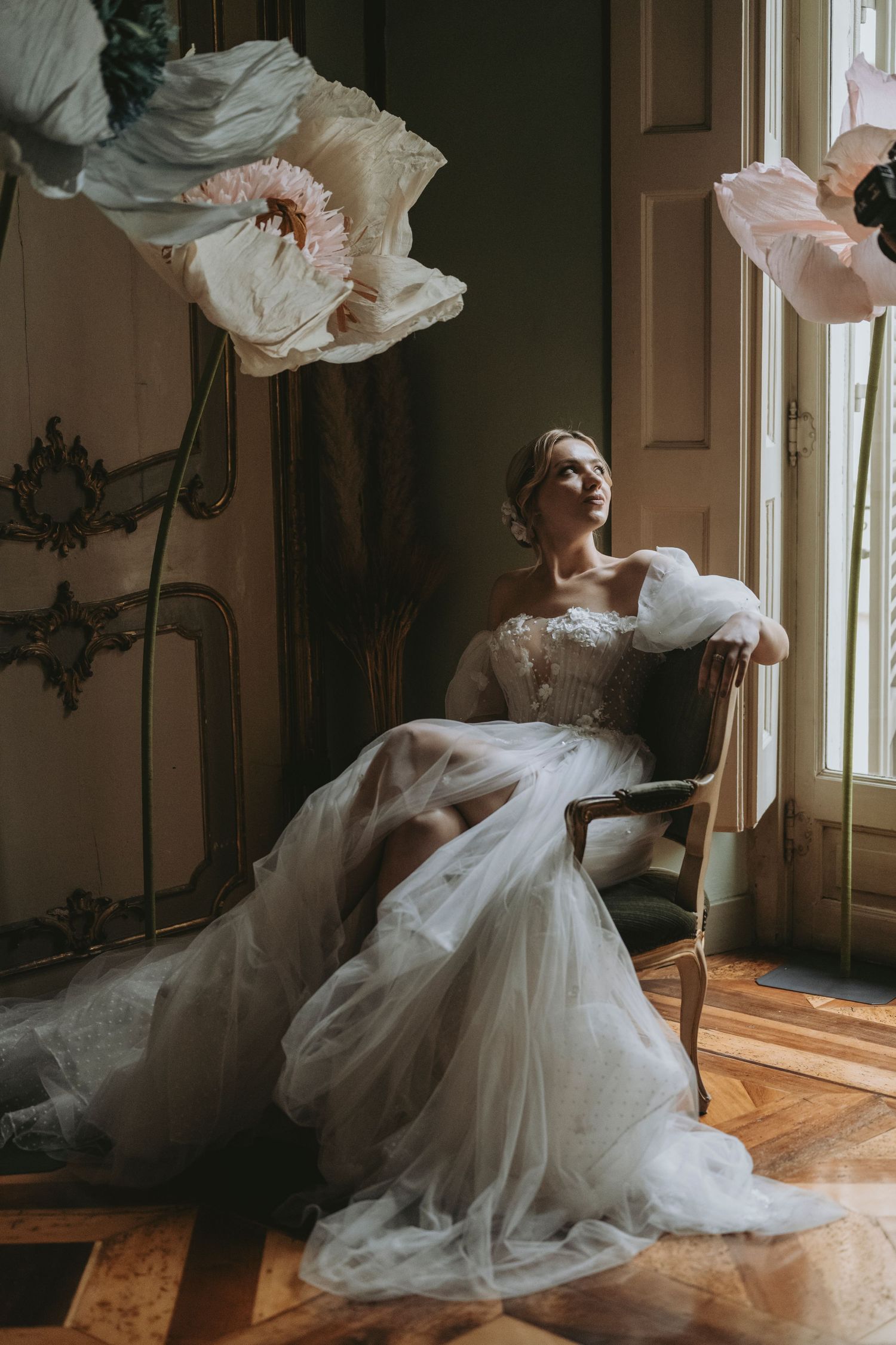 A flowing white wedding dress twirls gracefully in a sunlit room with hardwood floors and vintage decor.