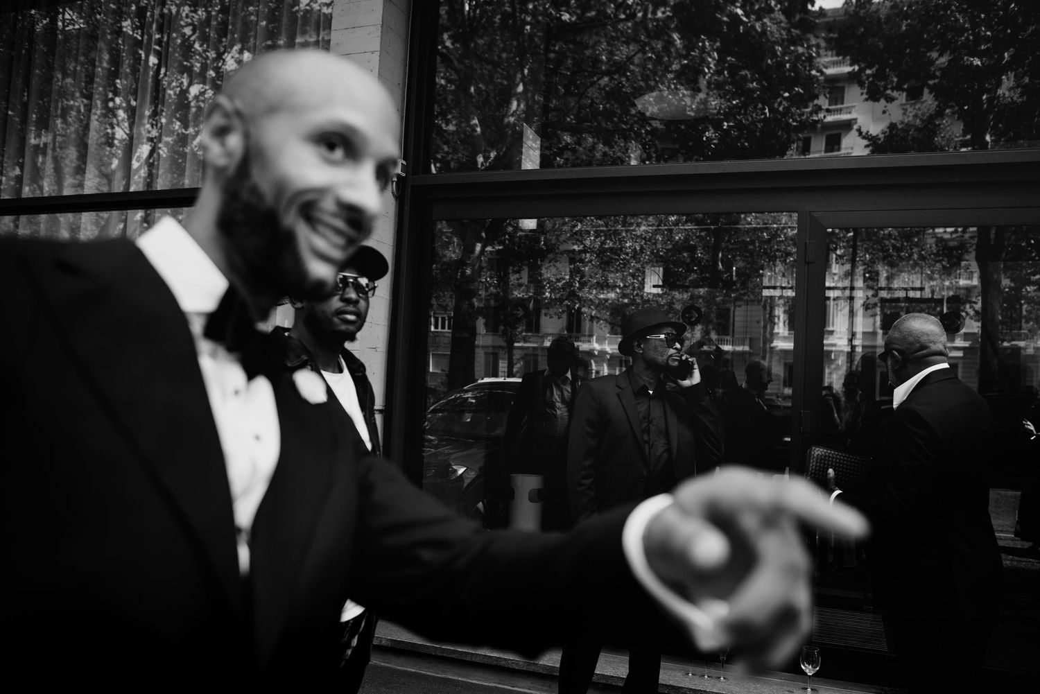 Black and white photo of men in tuxedos and bow ties smiling at a formal event.