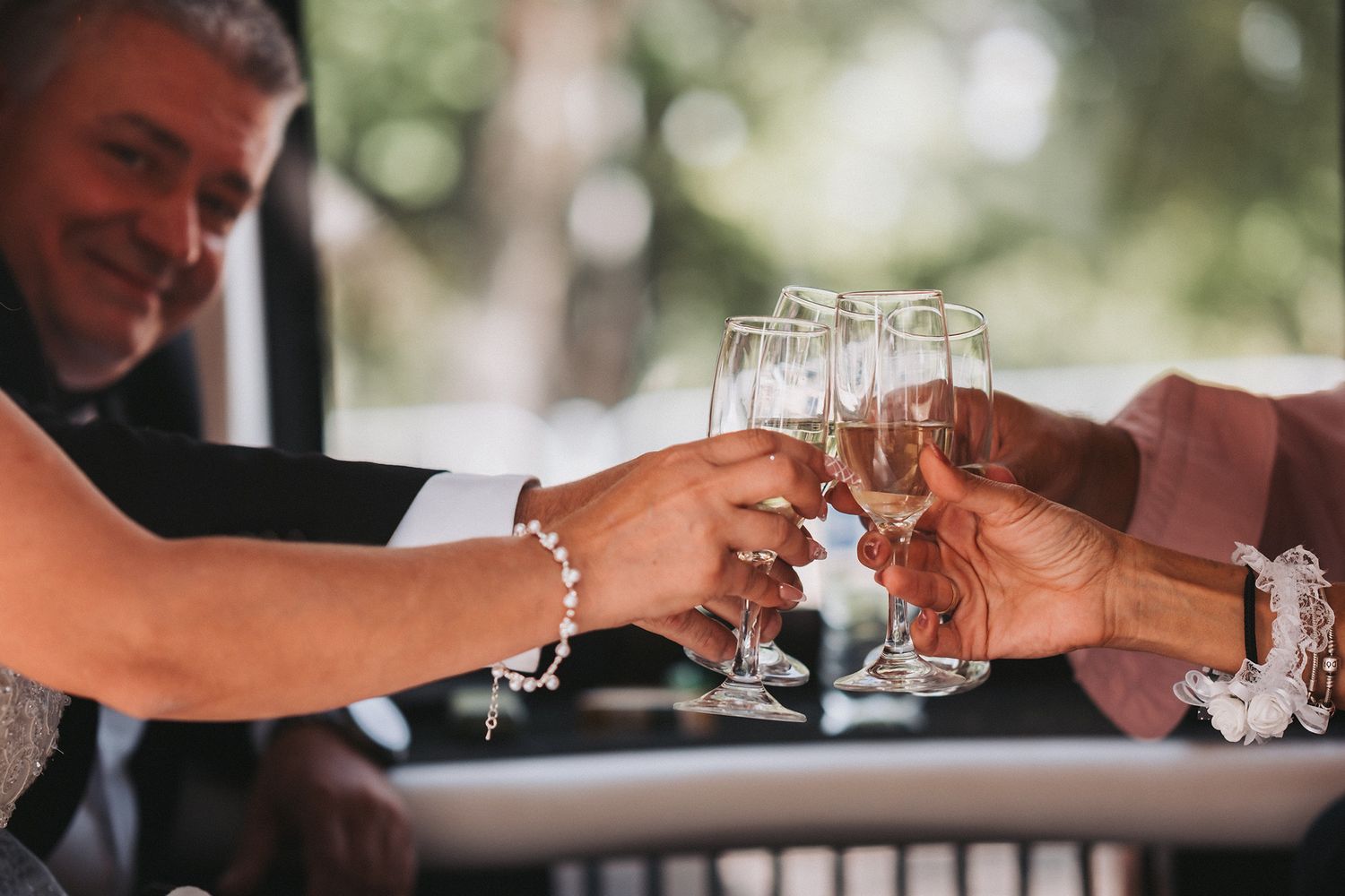 Wedding guests toasting with champagne glasses during an outdoor celebration.
