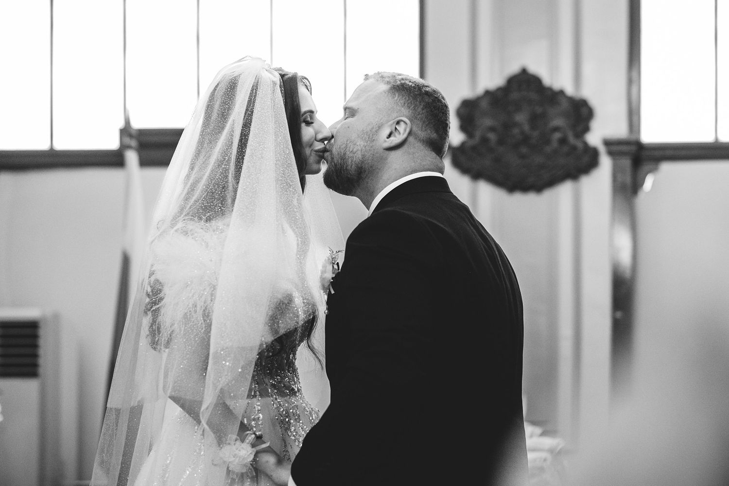 Black and white wedding ceremony photos showing intimate moments in a church setting.