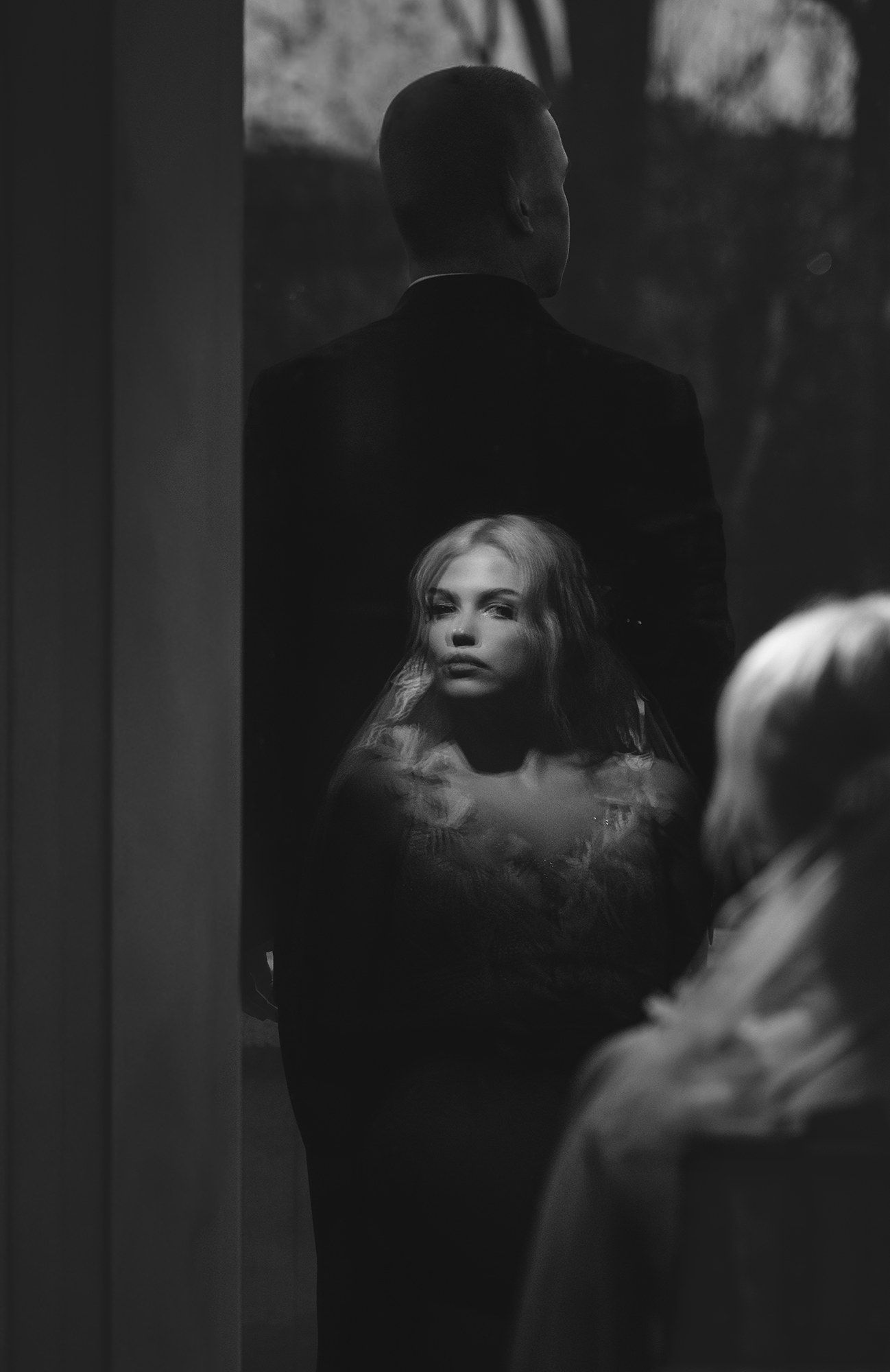 Moody black and white portrait with dramatic shadows and lighting effects.