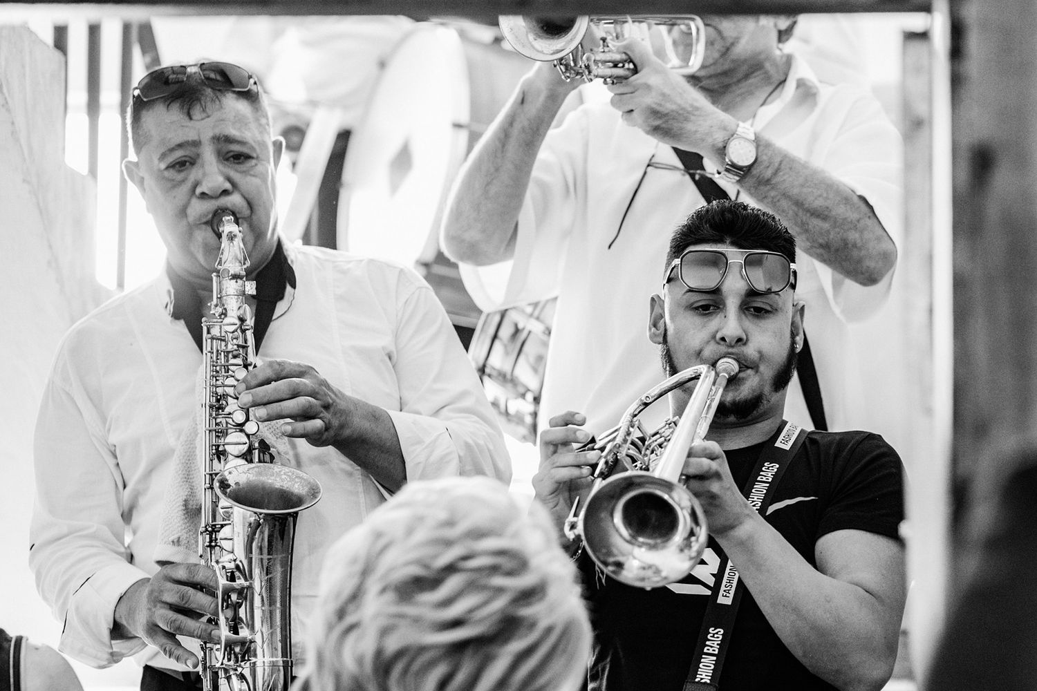 Black and white photo of brass band musicians performing at wedding celebration.
