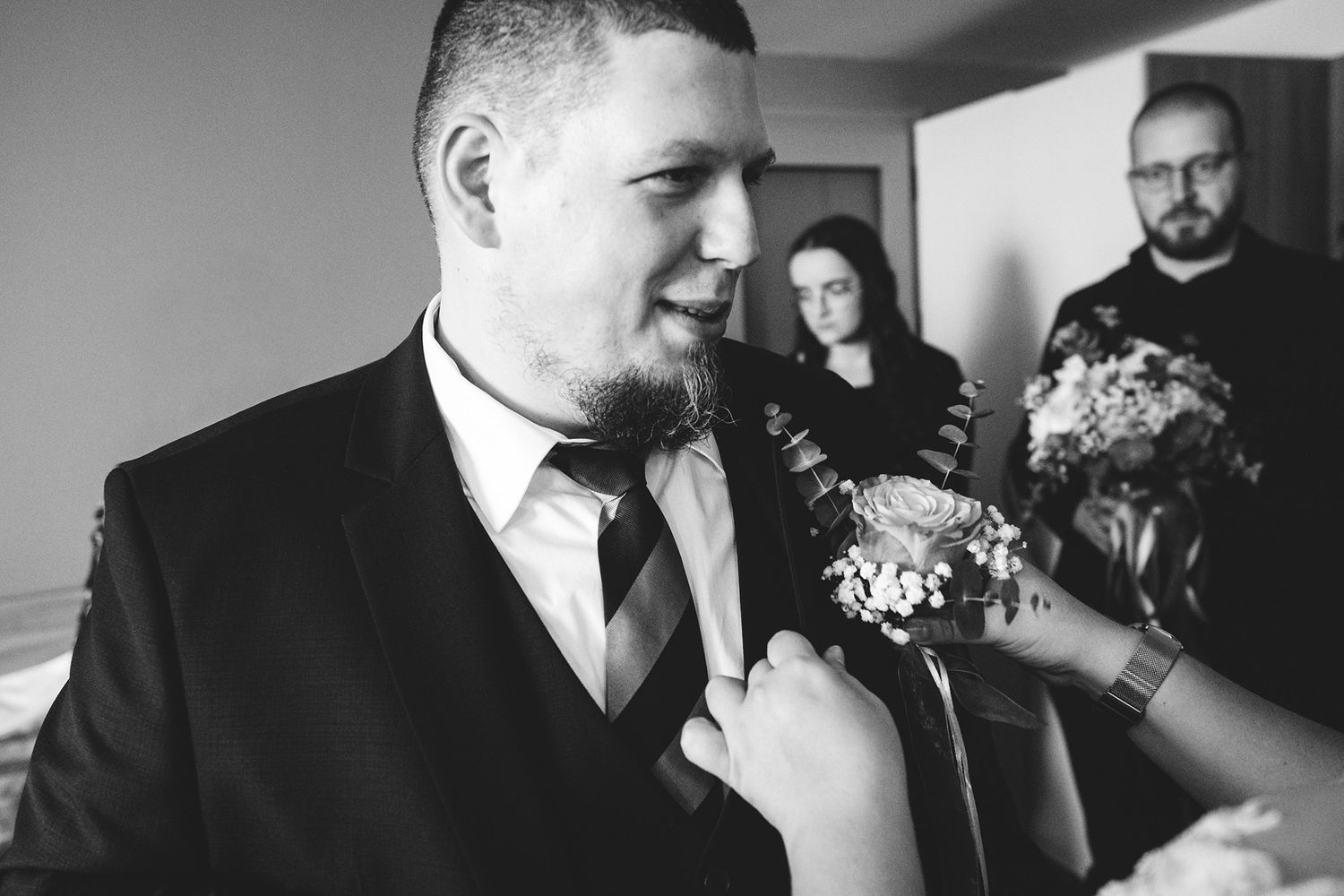 Formal wedding party portraits in black and white showing elegant attire and bouquets.