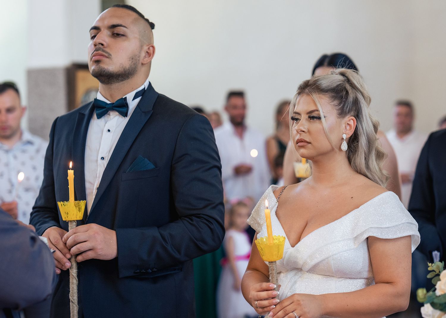 Wedding reception guests enjoying drinks and conversation in formal attire.