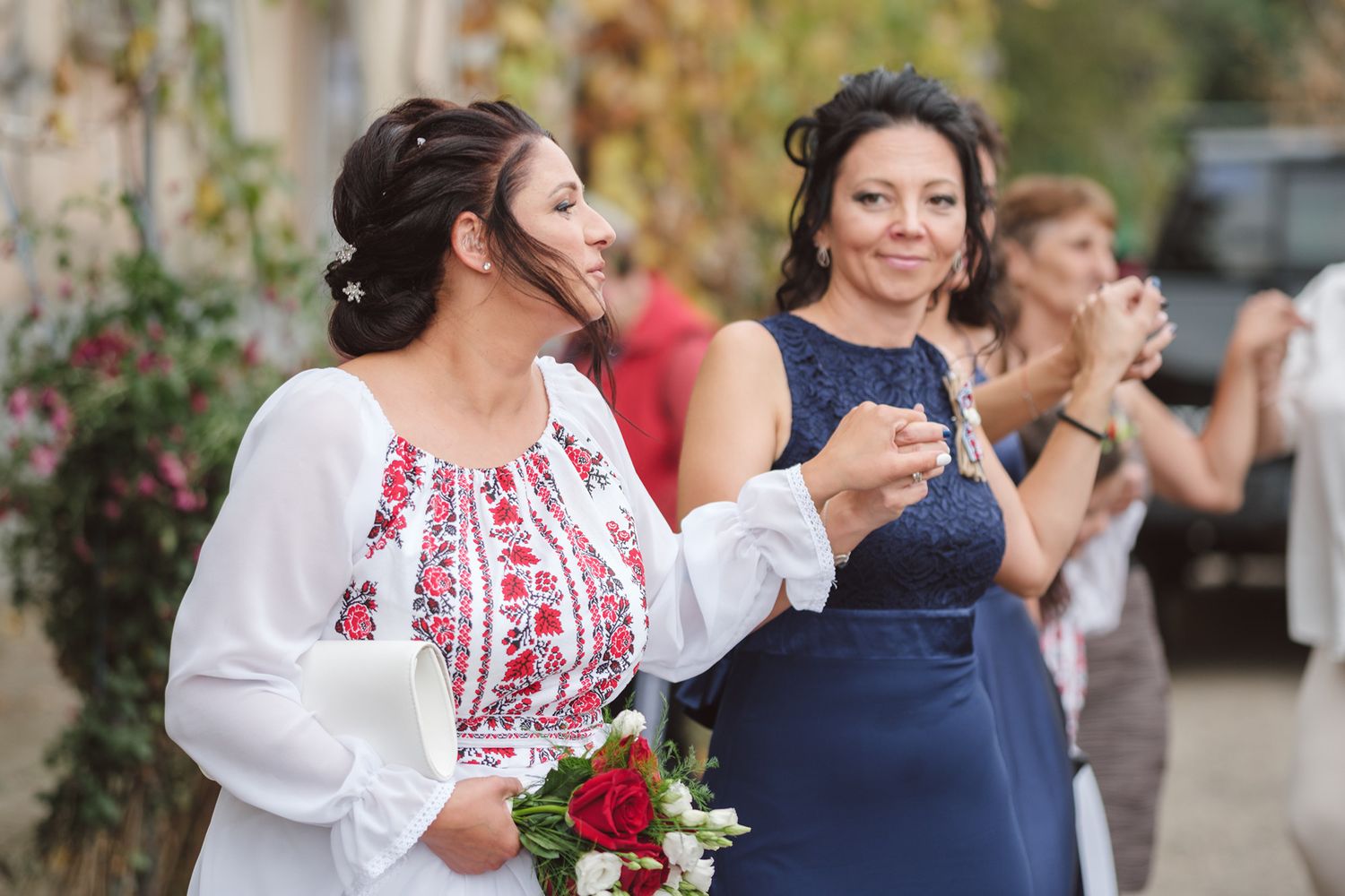 Wedding guests in traditional embroidered attire celebrating outdoors.