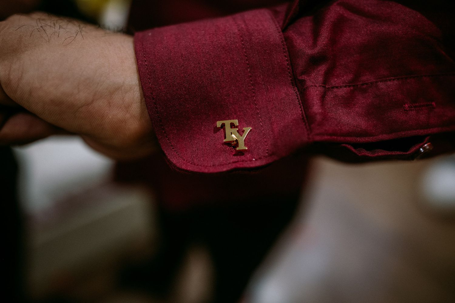 Close-up detail shot of burgundy wedding accessories and decor elements.