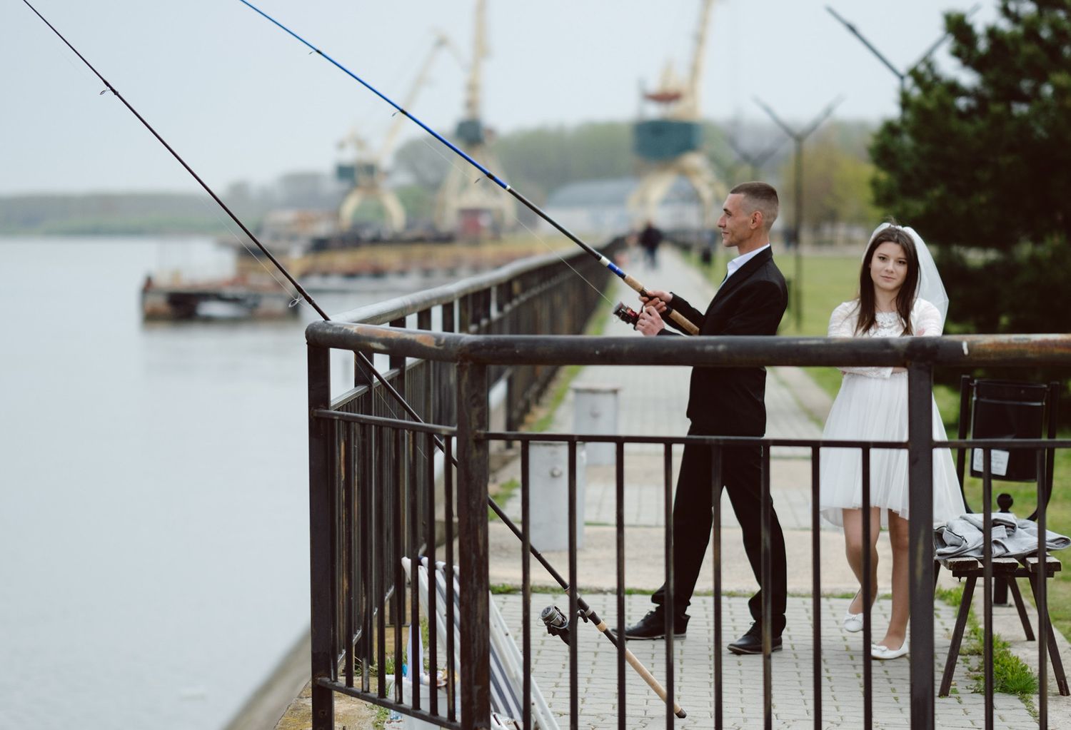 Wedding party walking along a waterfront railing during an outdoor photo session.