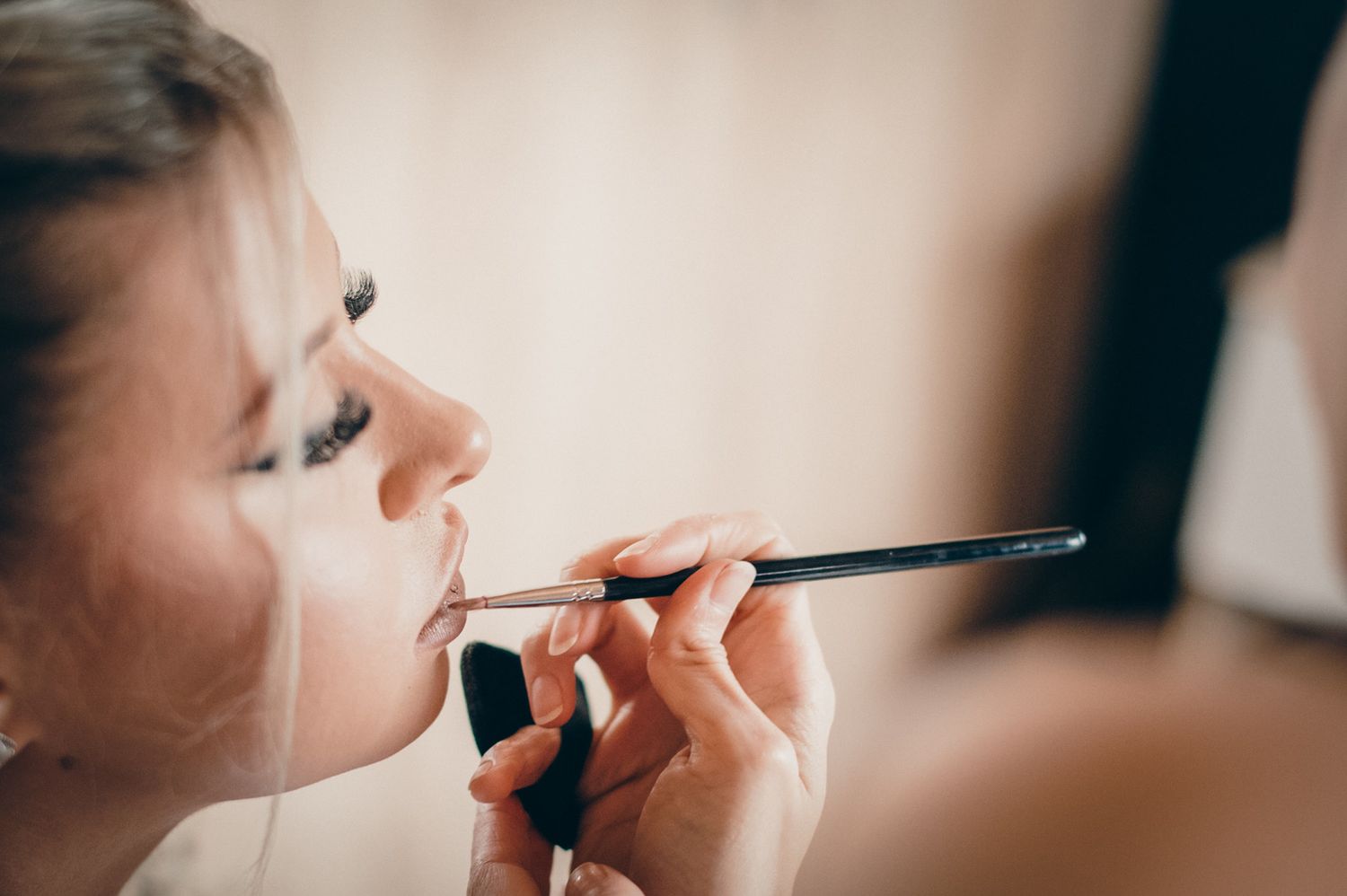 Close-up shots of makeup application during wedding preparations.