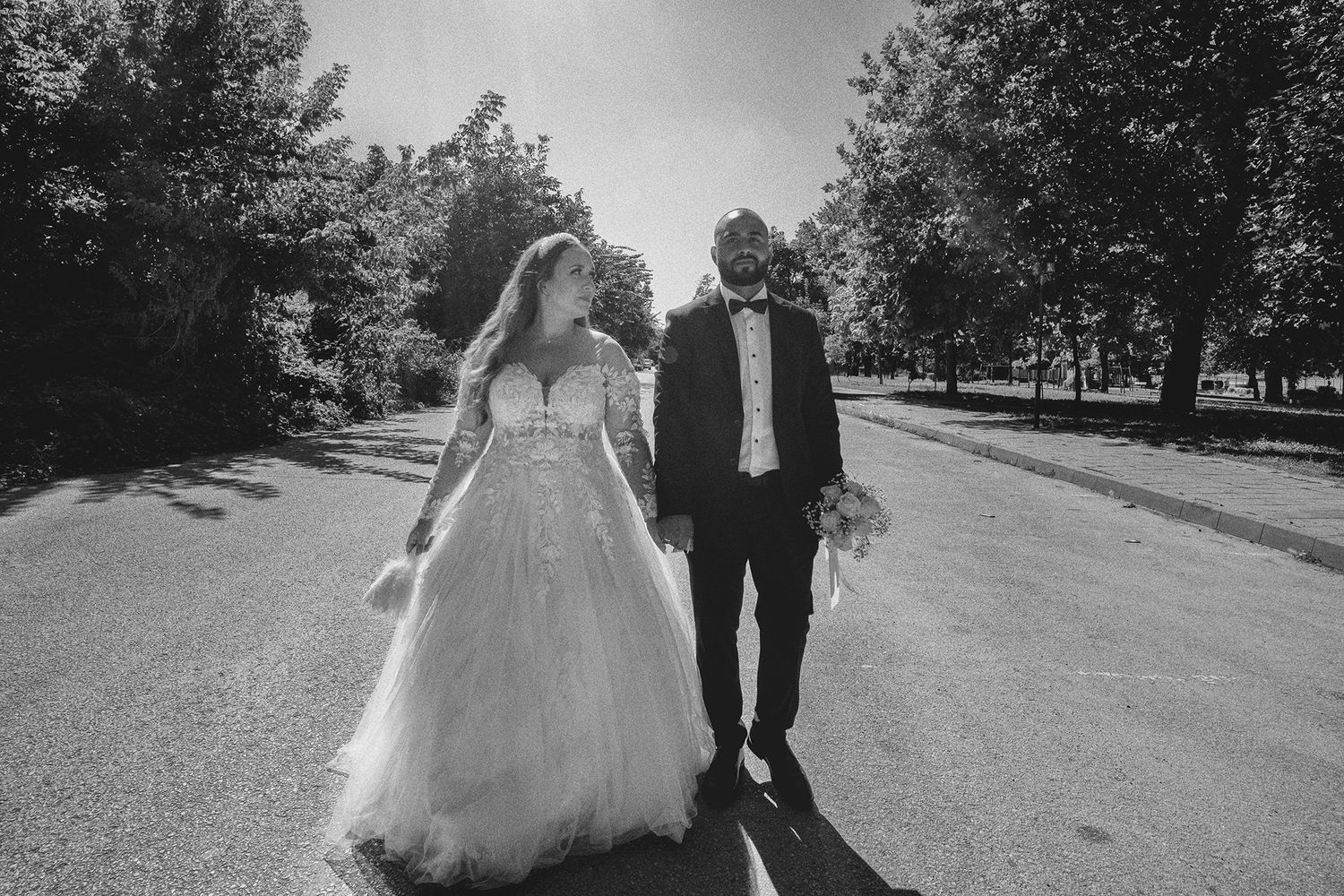Black and white outdoor wedding photos taken in a scenic park setting.