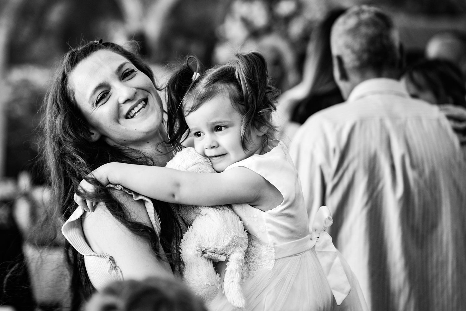 Black and white candid moment at a wedding celebration with formal attire.