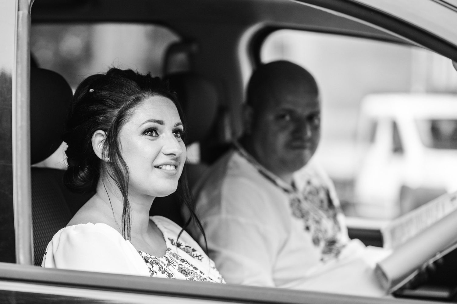 View through car window during wedding transportation.