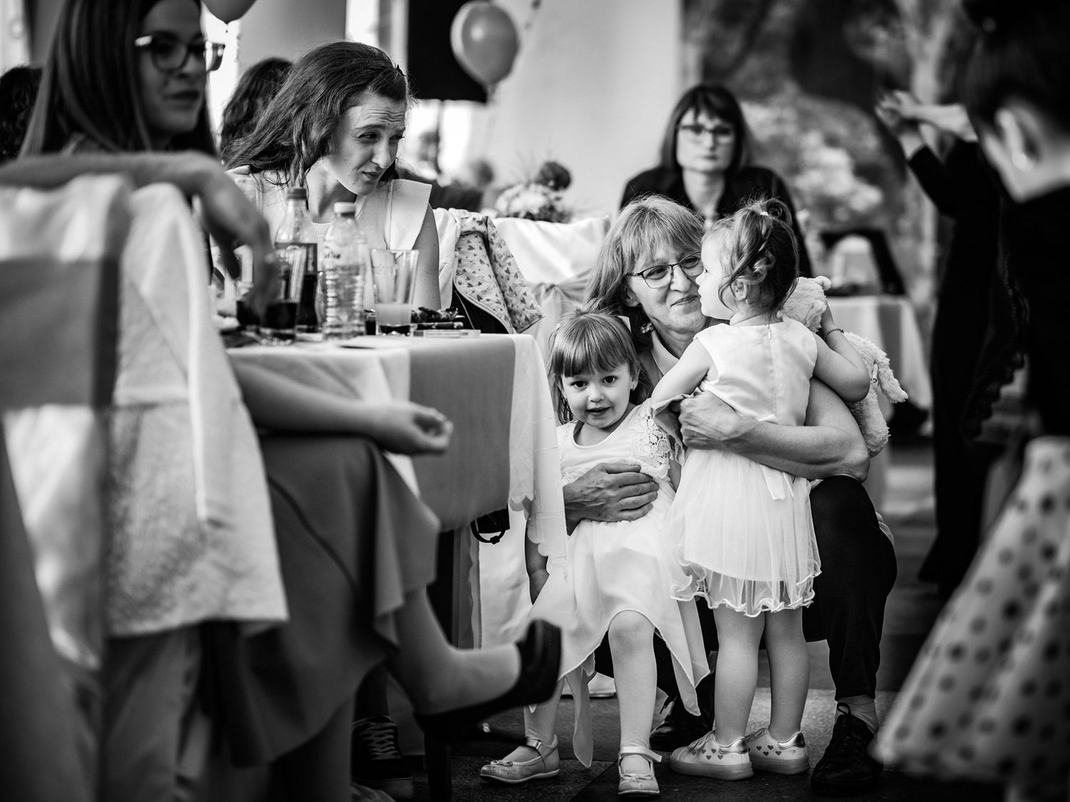 Black and white candid shot of wedding guests enjoying the reception.