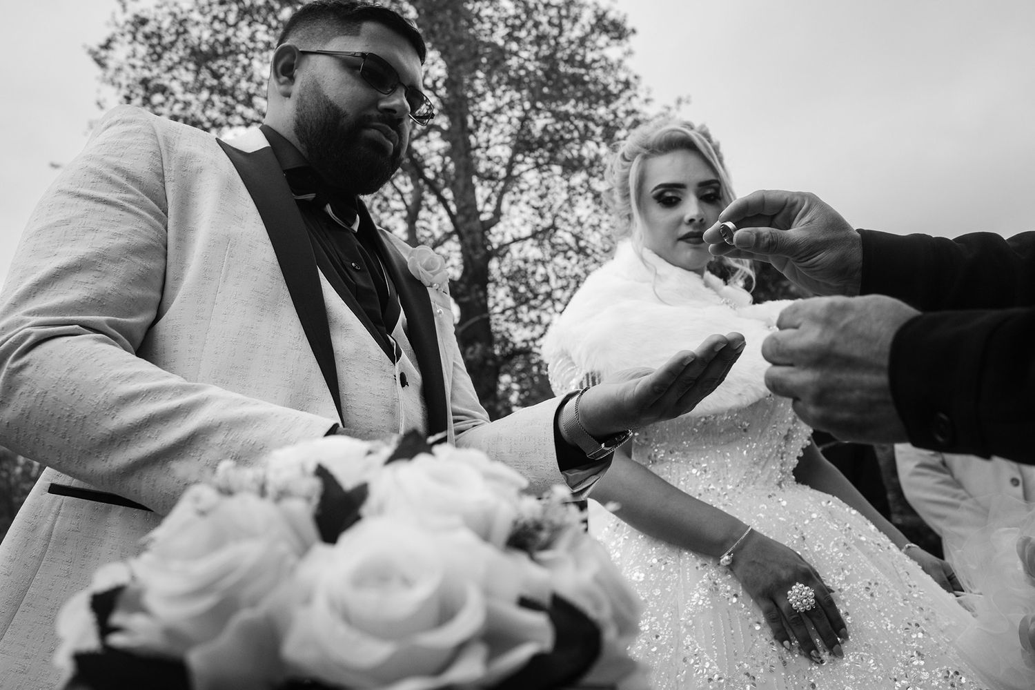 Black and white wedding photos showing close-up details of a couple's outdoor celebration.