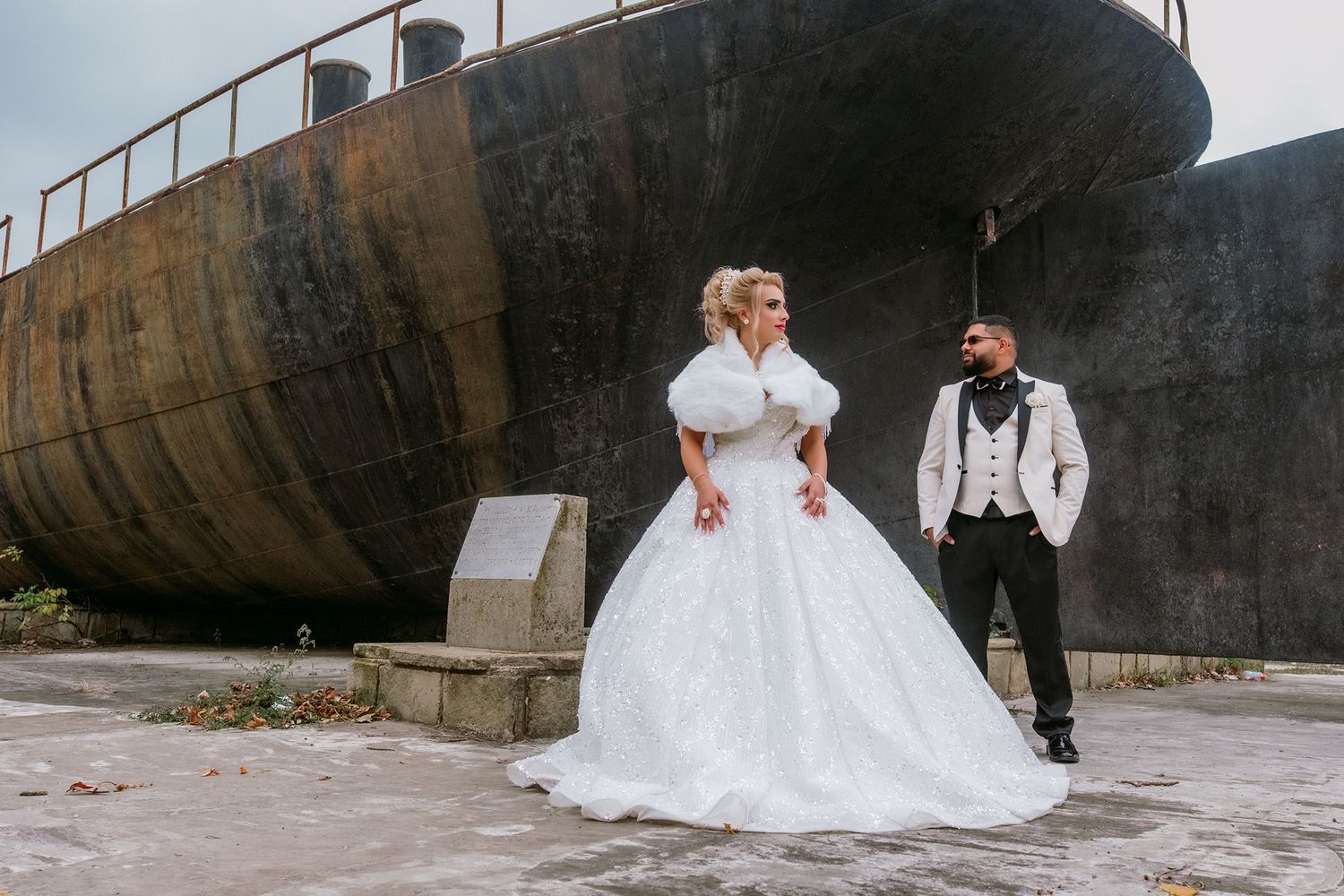 Wedding portraits taken against industrial backdrop of large metal structures.