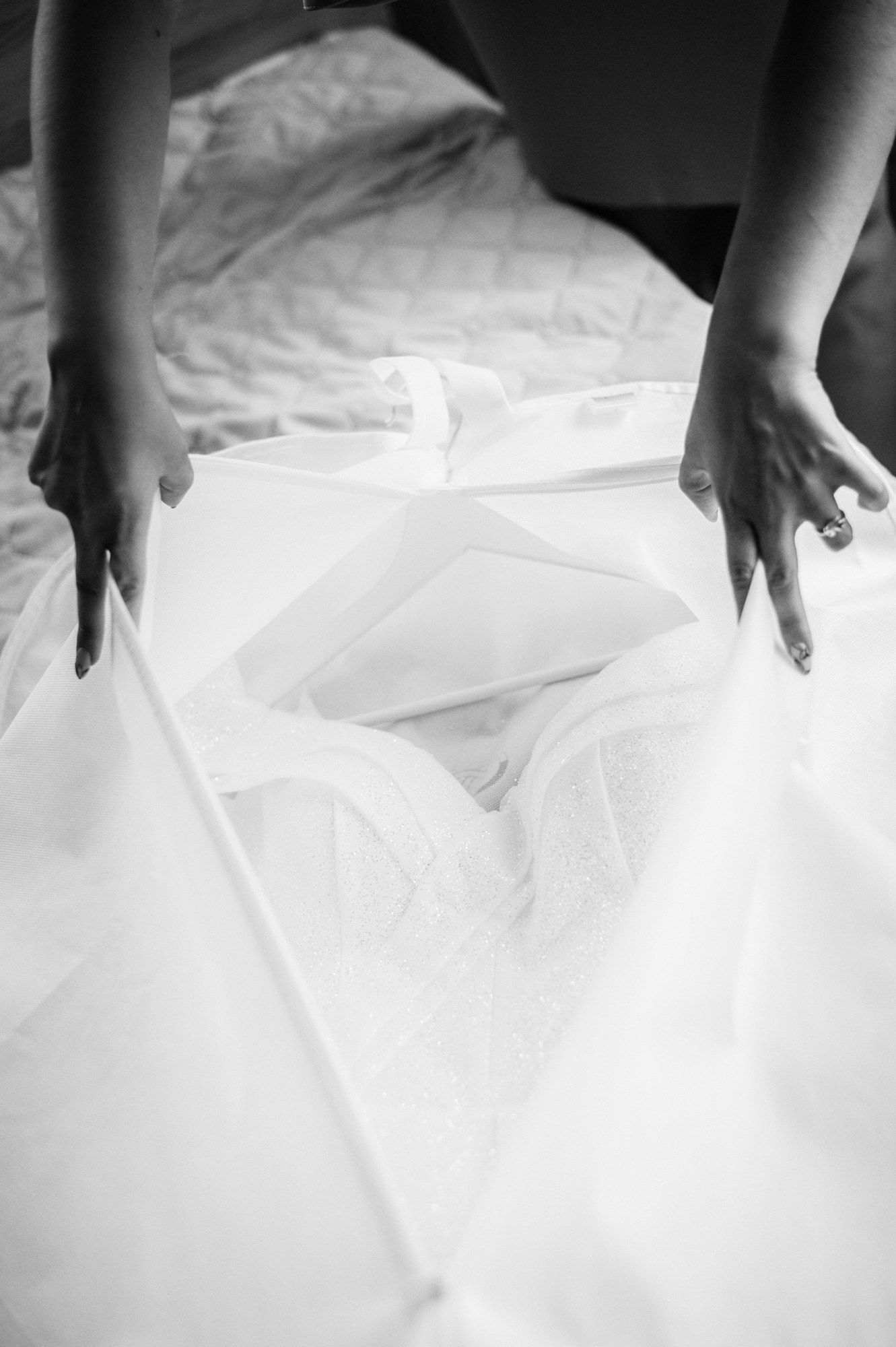 Detail shots of hands touching white wedding dress fabric.