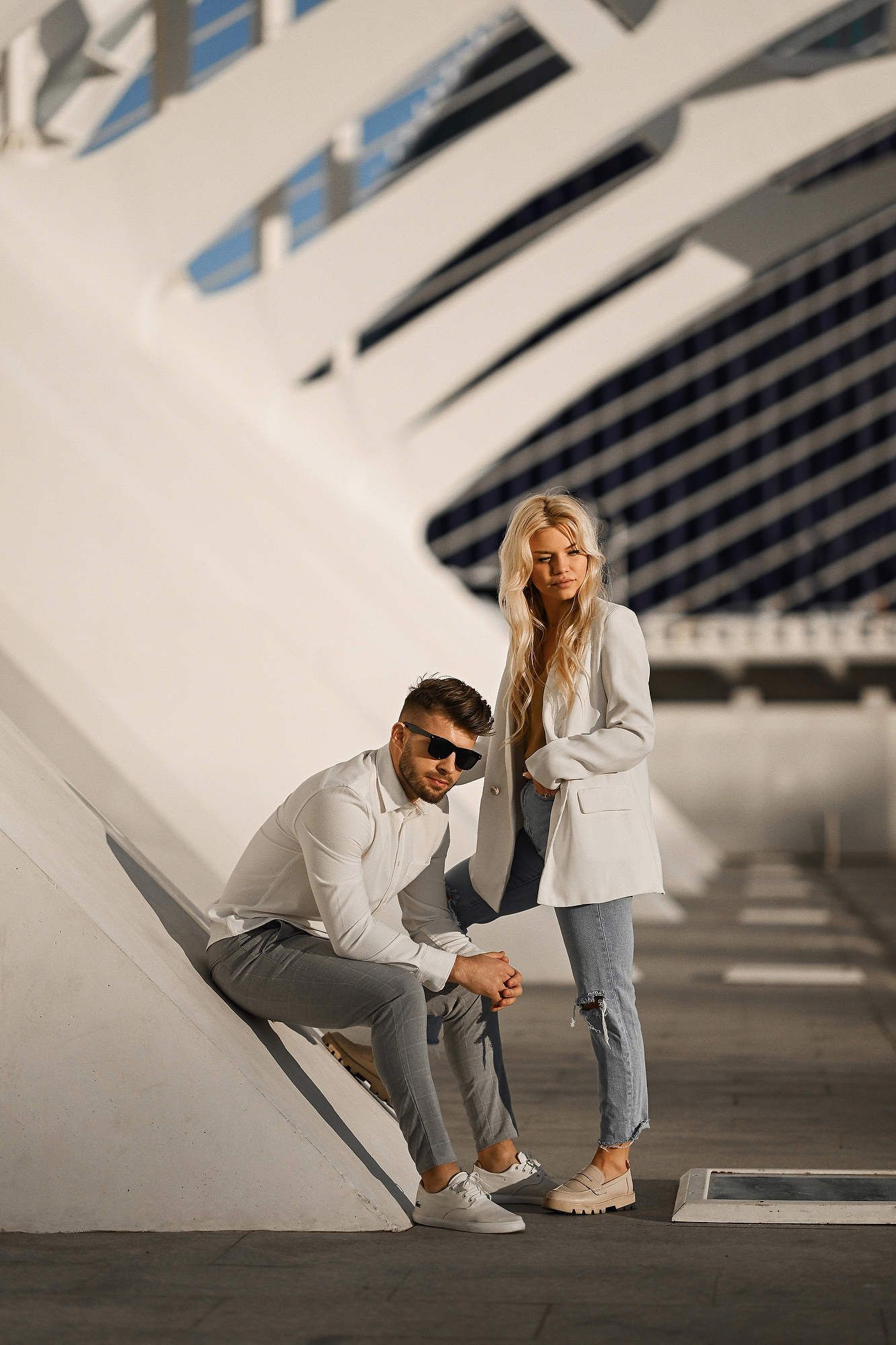 Young couple holding hands walking at the City of Arts and Sciences in Valencia during an engagement session.