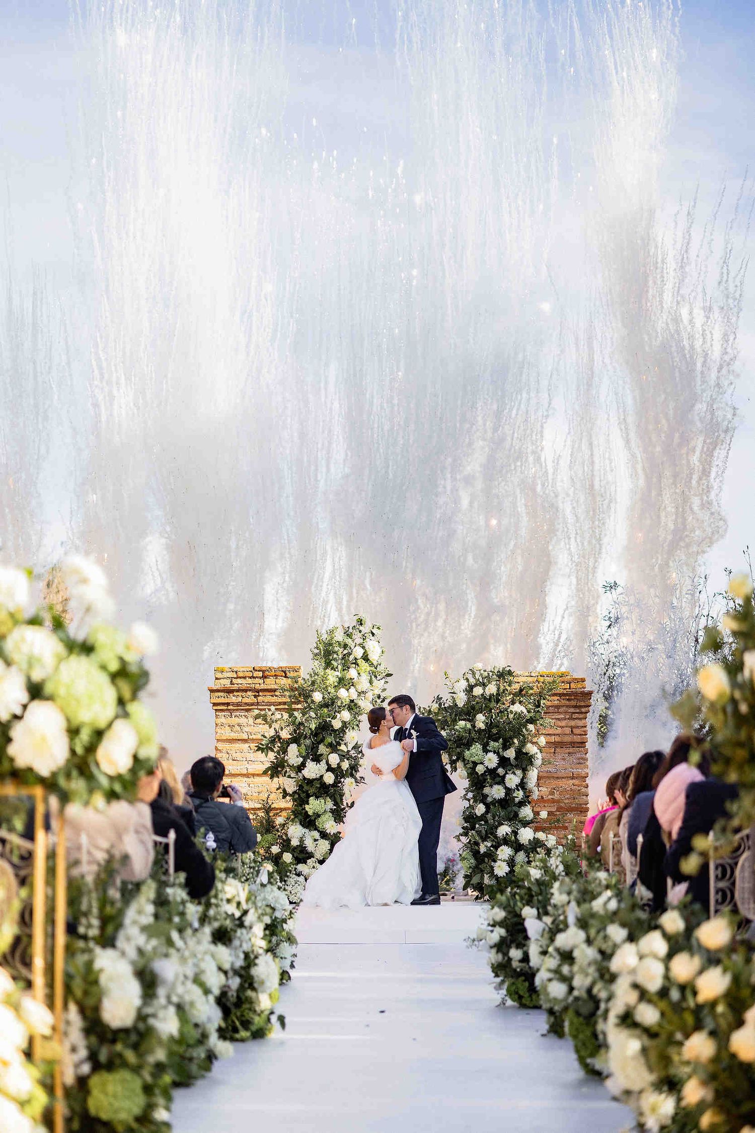 Spectacular fireworks display during the couple's first kiss at their courtyard ceremony in La Cartoixa d'Ara Christi, Spain.