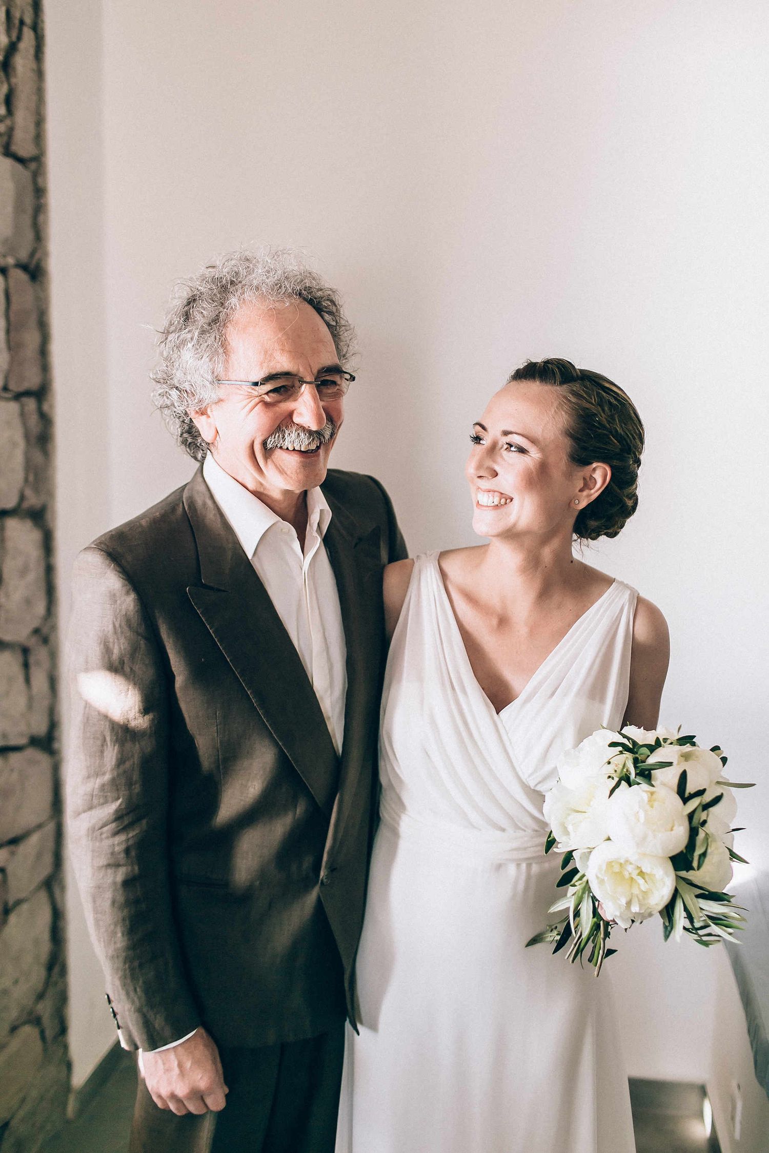 Candid and emotional moment of the bride with her father at their family home in Milos