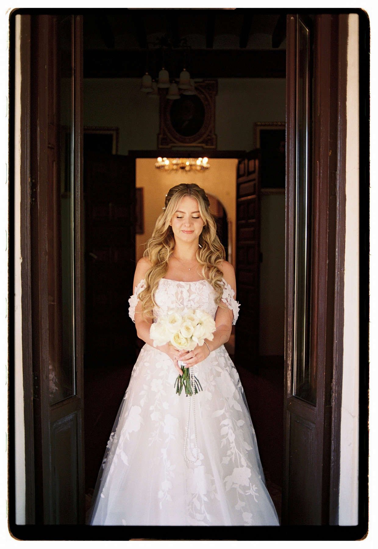 Bride looking down at her wedding bouquet on a balcony at Finca El Senyoret villa near Alicante.