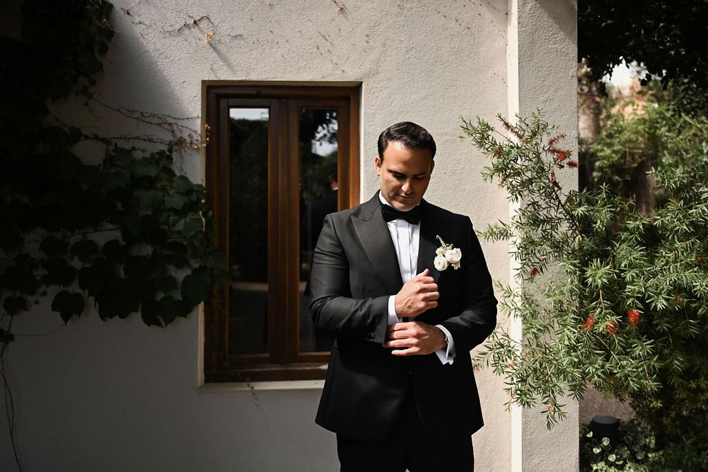 The groom adjusting his luxury cufflinks in the courtyard of Finca del Canónigo before the first look. Sophisticated wedding details.