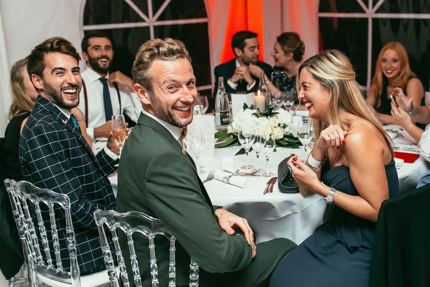 Emotional wedding banquet at Château de Changy. Candid guest reactions and joyful celebration in the grand hall