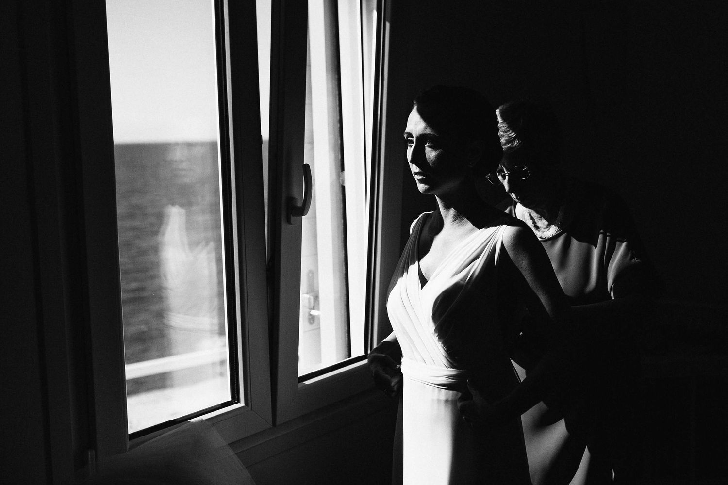 Documentary photography of mother helping the bride to put on her wedding dress.