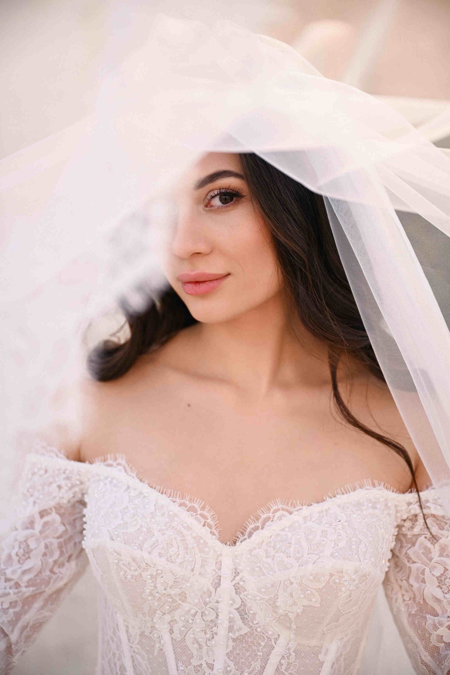 Close-up portrait of a bride wearing a delicate lace veil within the historic stone walls of Monasterio de Santa María de la Valldigna