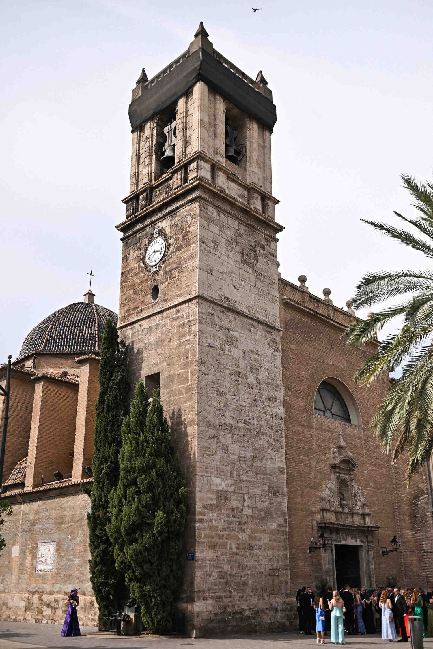 Exterior view of Parroquia de Santa Maria del Mar church in Valencia with wedding guests gathering outside.