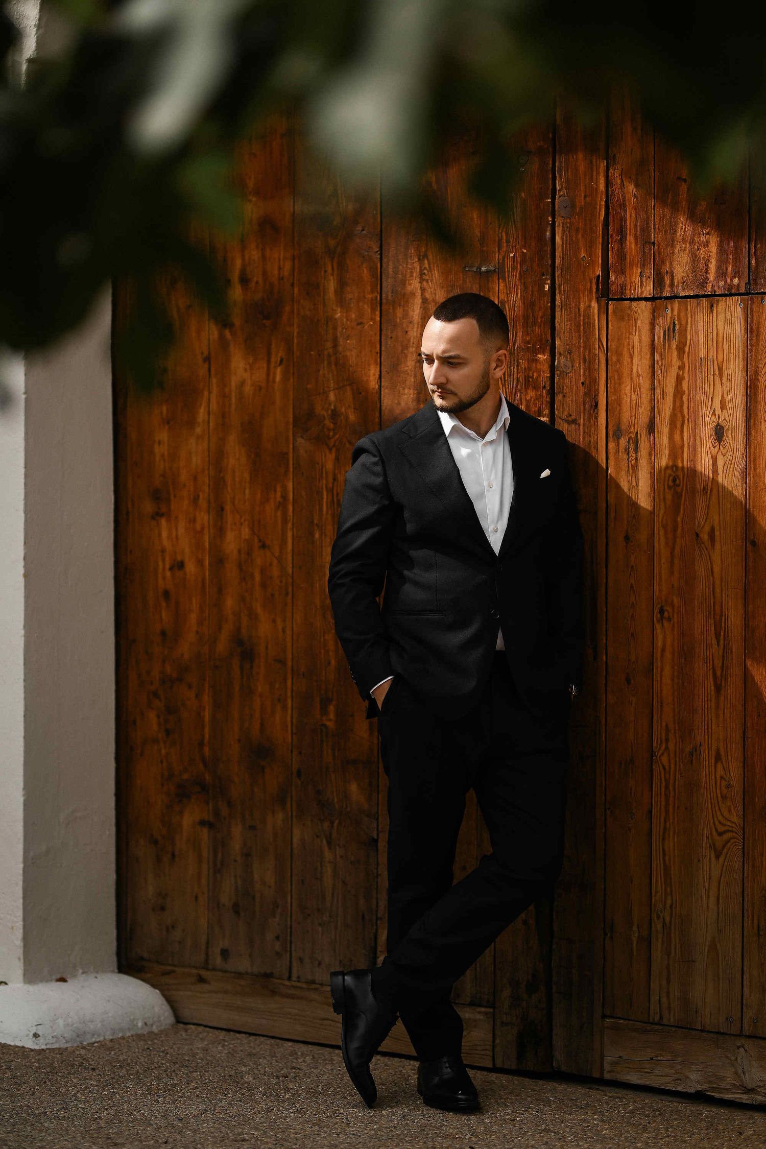 Refined editorial groom portrait captured against the raw industrial textures of El Telar de Miguel Martí
