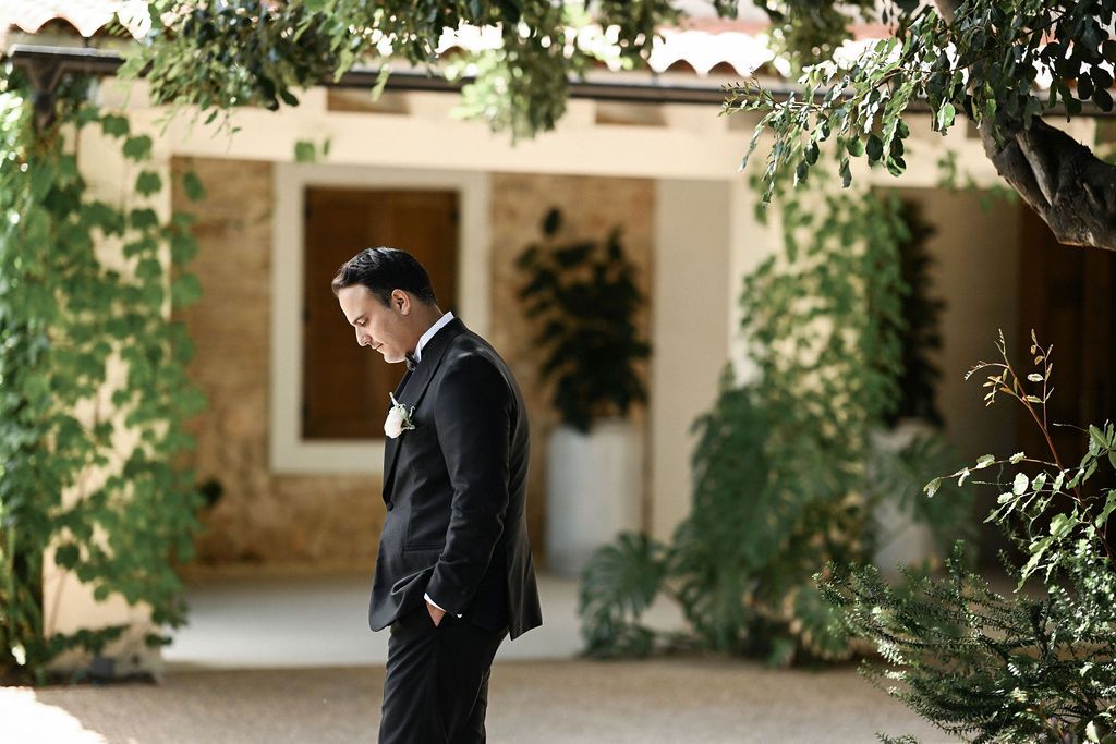 Stately portrait of the groom walking through the estate grounds, captured by a professional wedding photographer in Valencia, Spain.