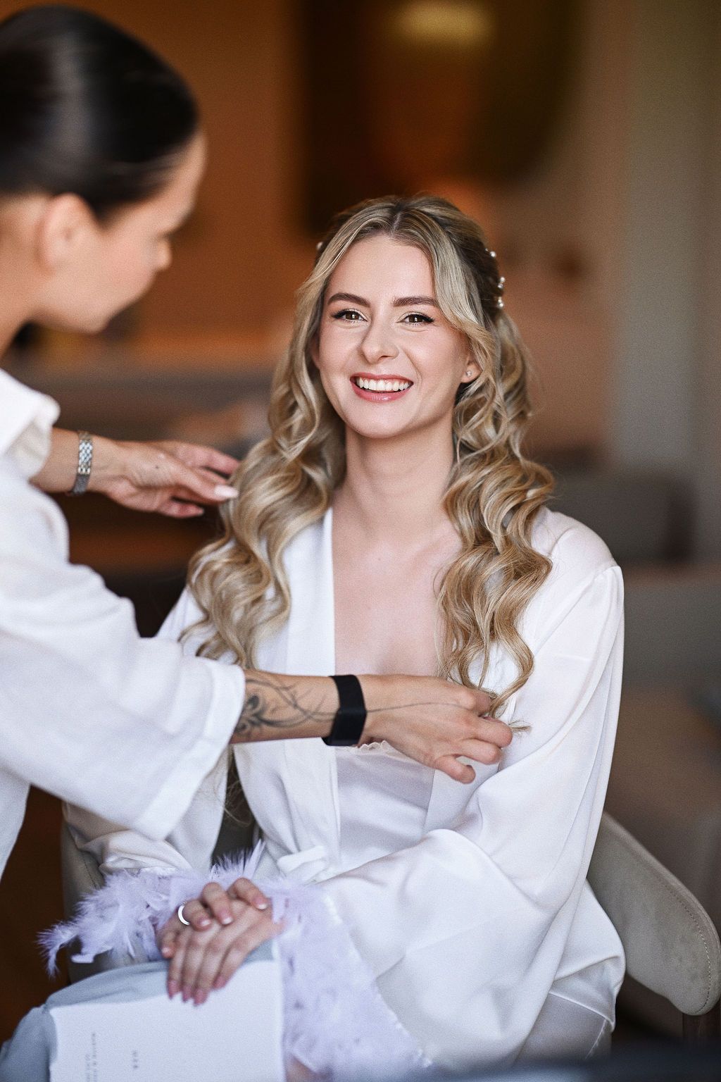 Makeup artist finishing the bride's wedding hairstyle in a bright room at Barcelo La Nucia Palms hotel near Benidorm. Captured by Darista.
