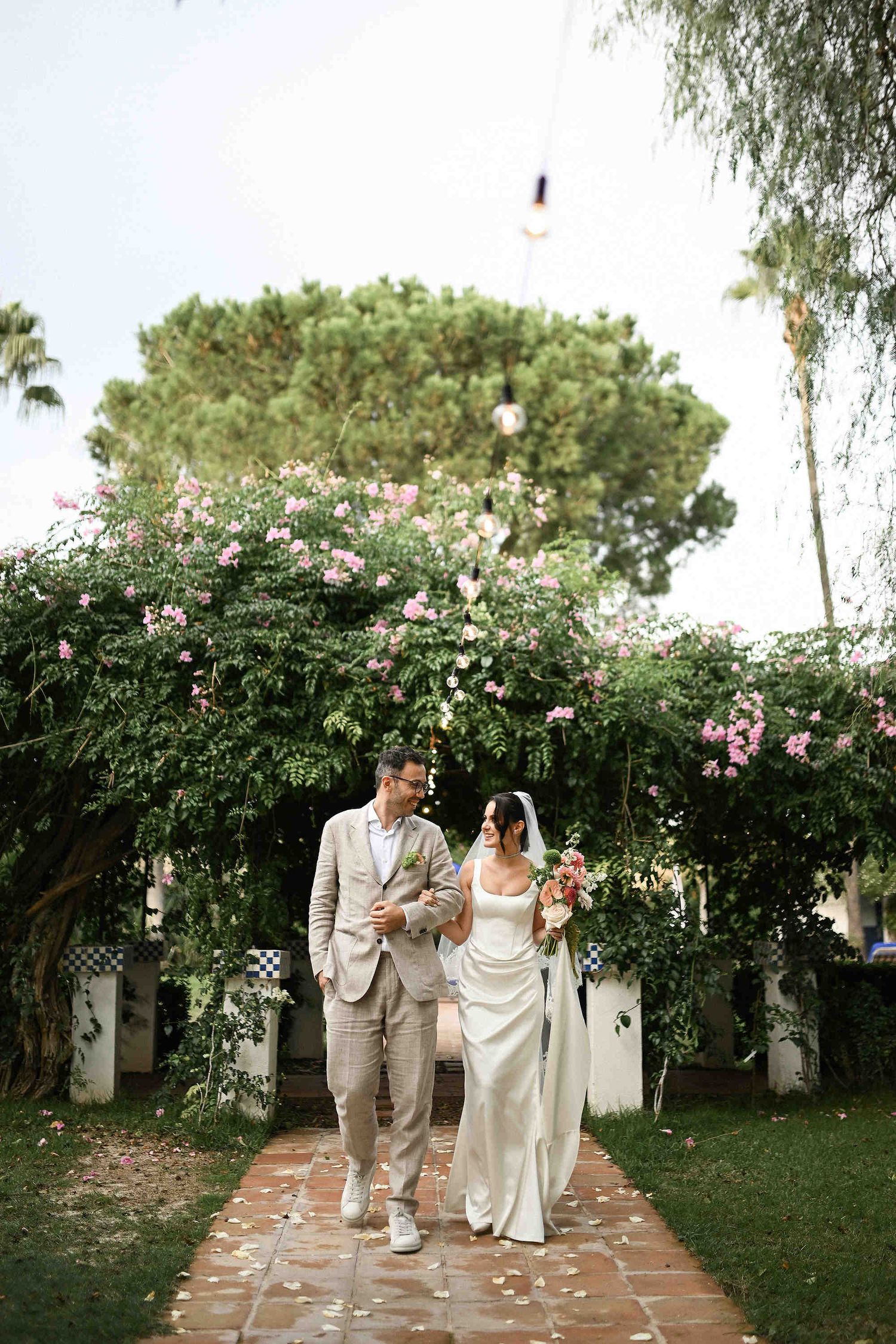 Candid and smiling bride and groom making their grand entrance into the garden wedding ceremony at Villa Paula