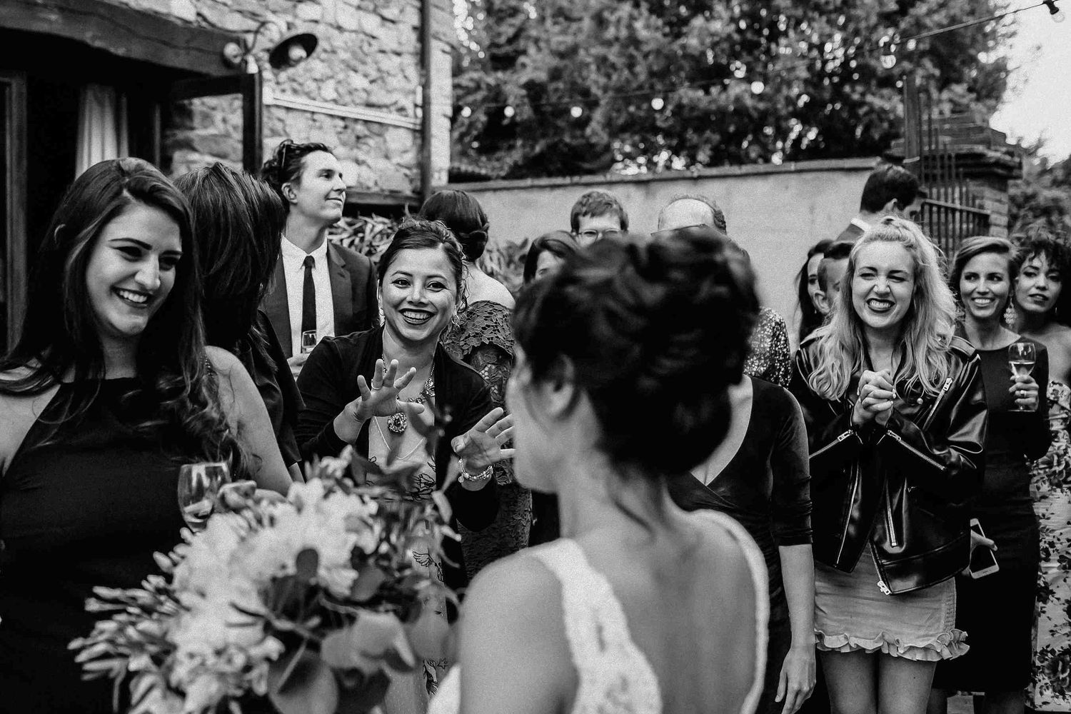 Black and white documentary wedding photography. Guests admiring bride during a candid, unposed moment at a Spanish villa - Darista Wedding