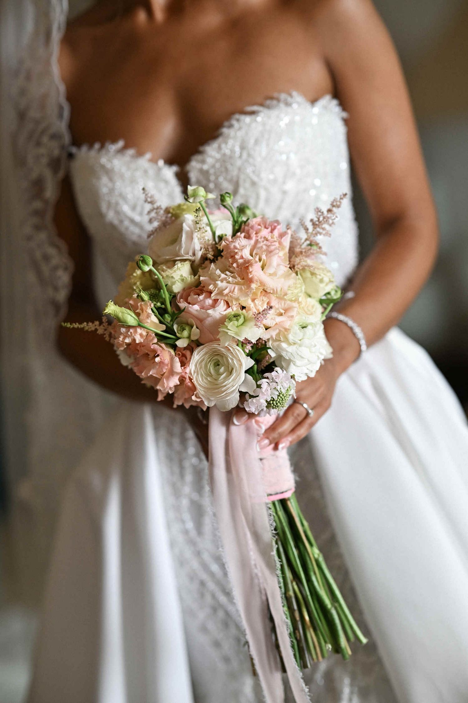 Close-up of a bride holding a delicate pastel pink and white rose bouquet at a Valencia wedding photoshoot.