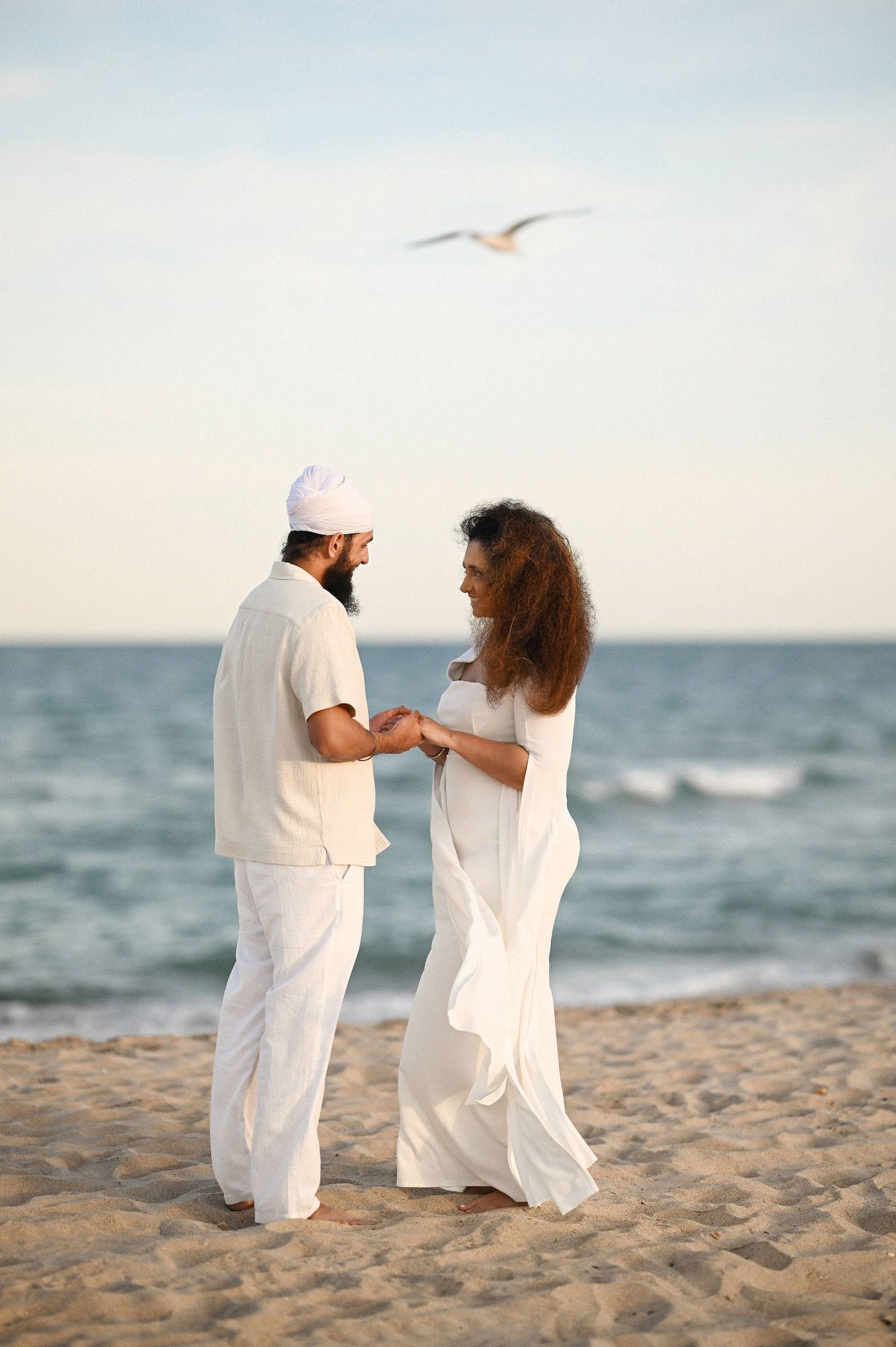 Couple holding hands on Valencia beach before a surprise marriage proposal - candid engagement session