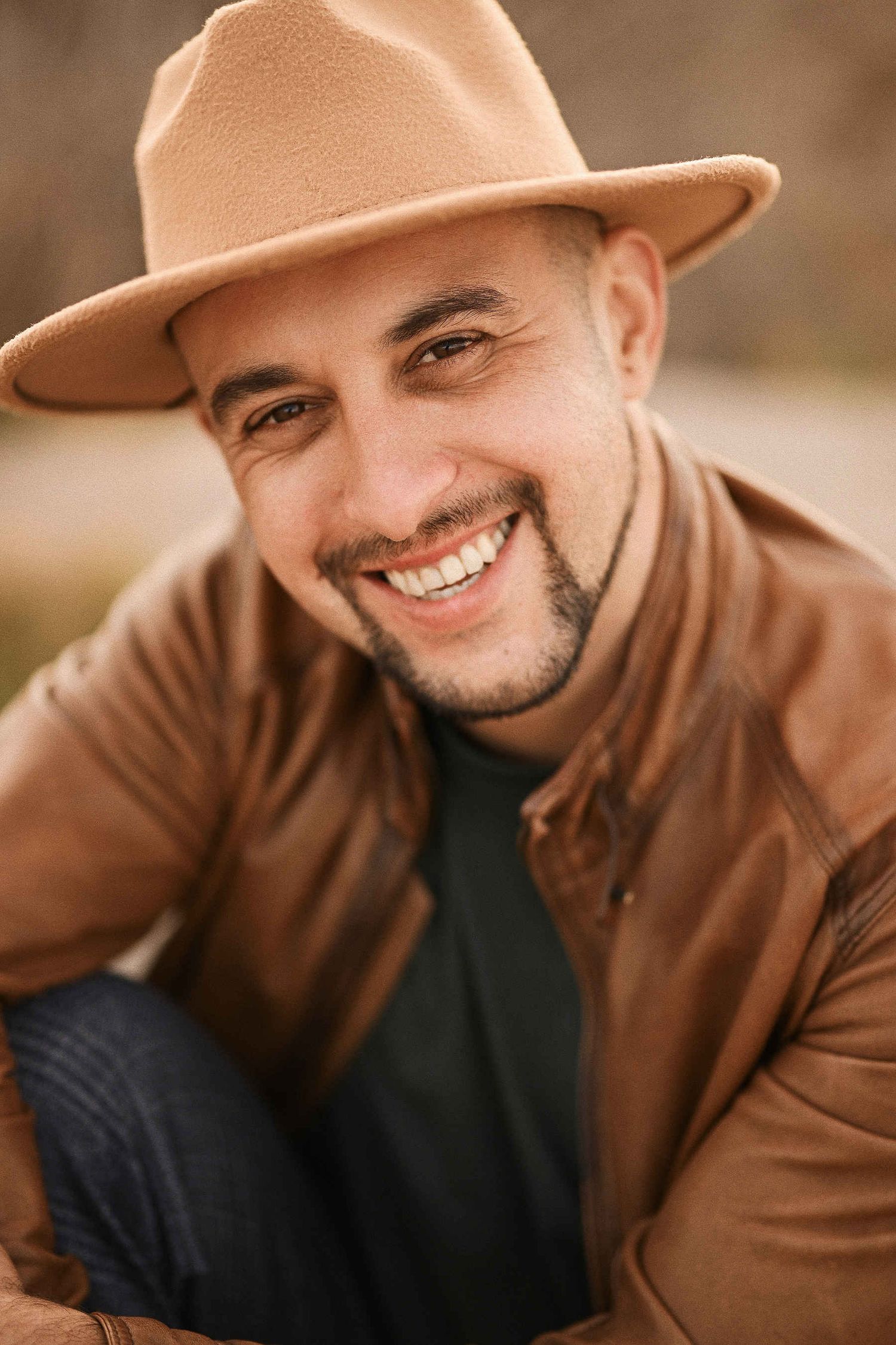 Portrait of a man in a hat preparing for a surprise proposal on the beach in Valencia