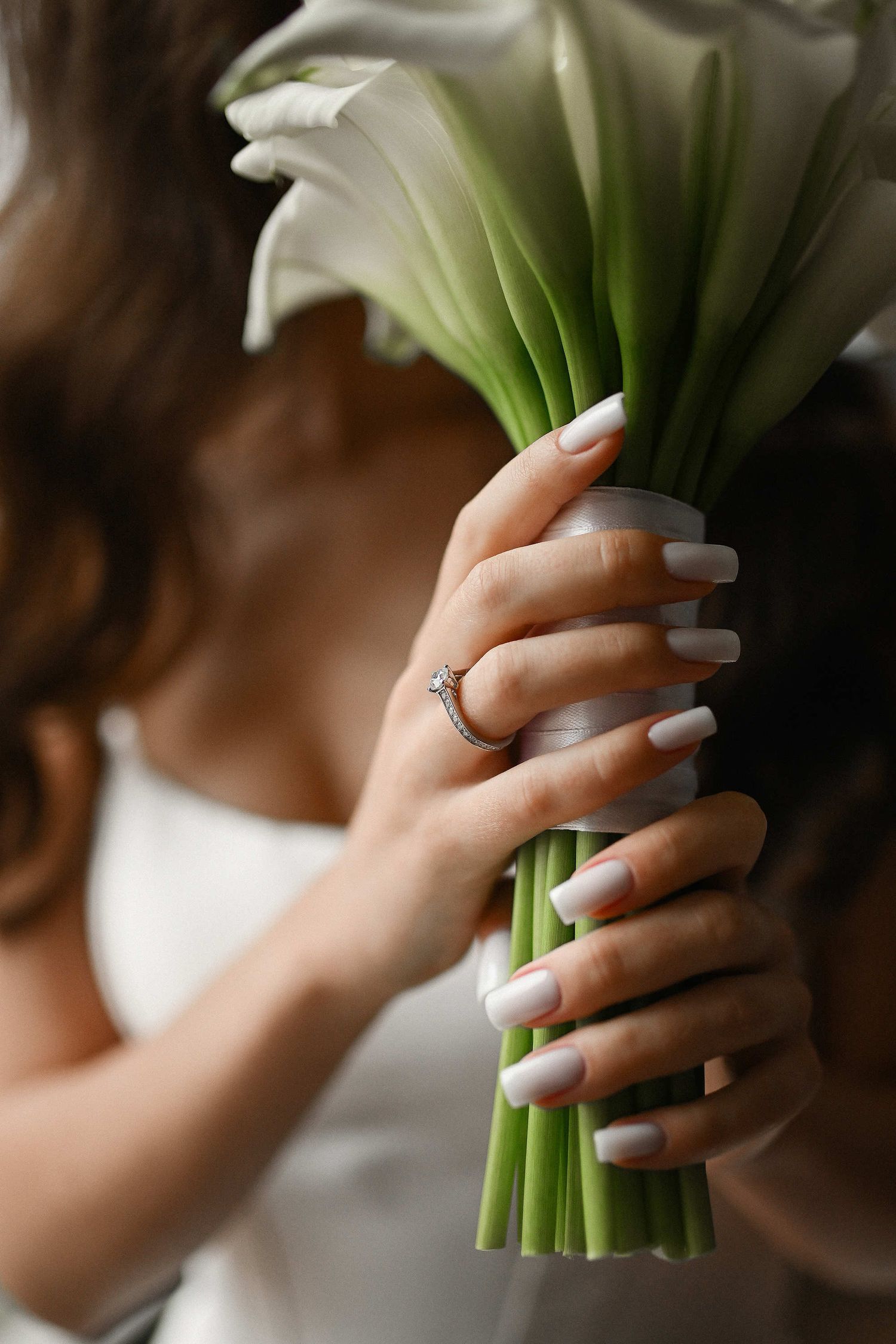 Close-up of a minimalist wedding bouquet with calla lilies, captured in a clean editorial style