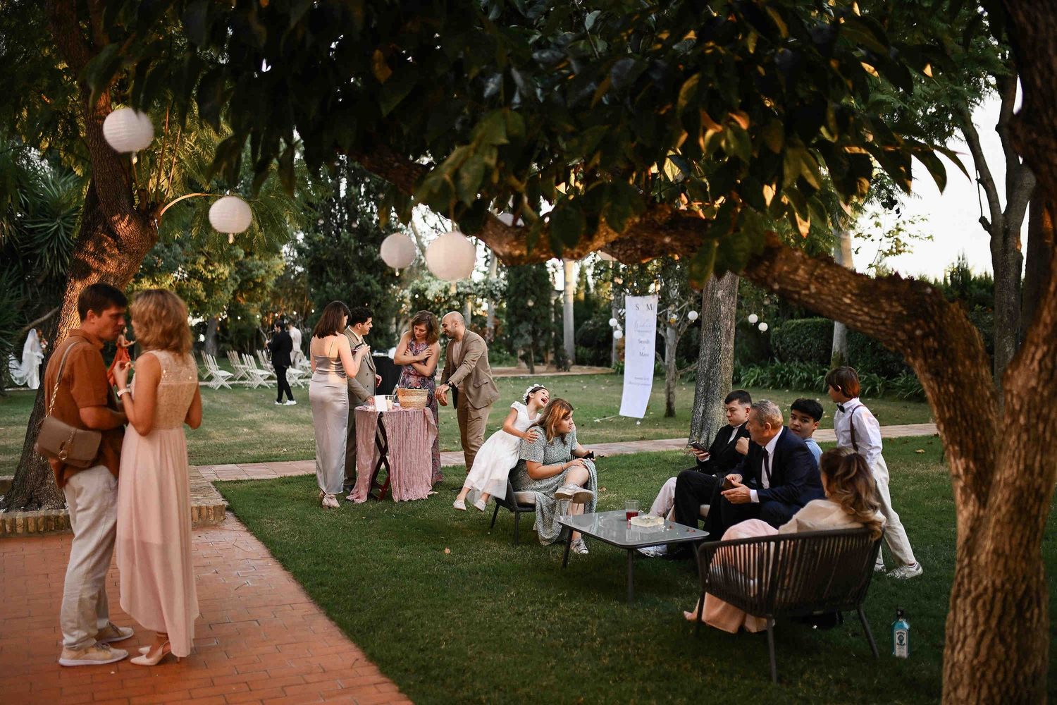 Candid moments of guests socializing and enjoying the relaxed garden party atmosphere at Villa Paula