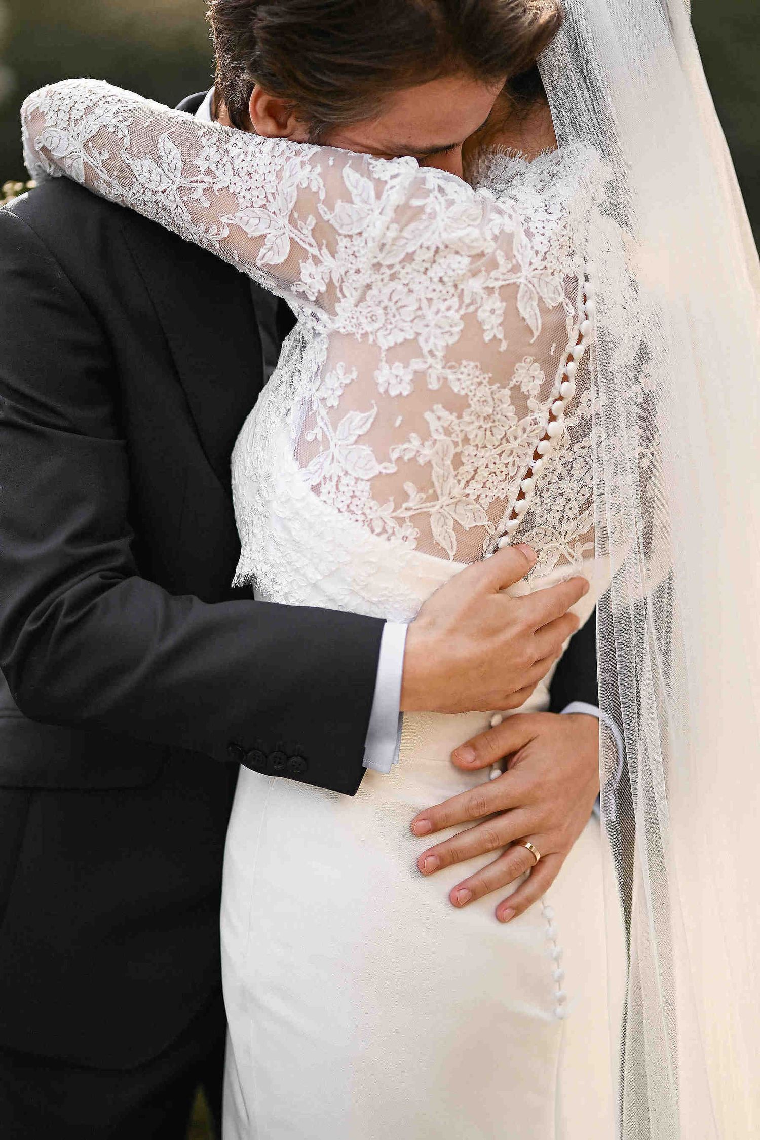 Romantic wedding photography. The groom embracing the bride tenderly, capturing a sincere emotional moment in a Mediterranean setting