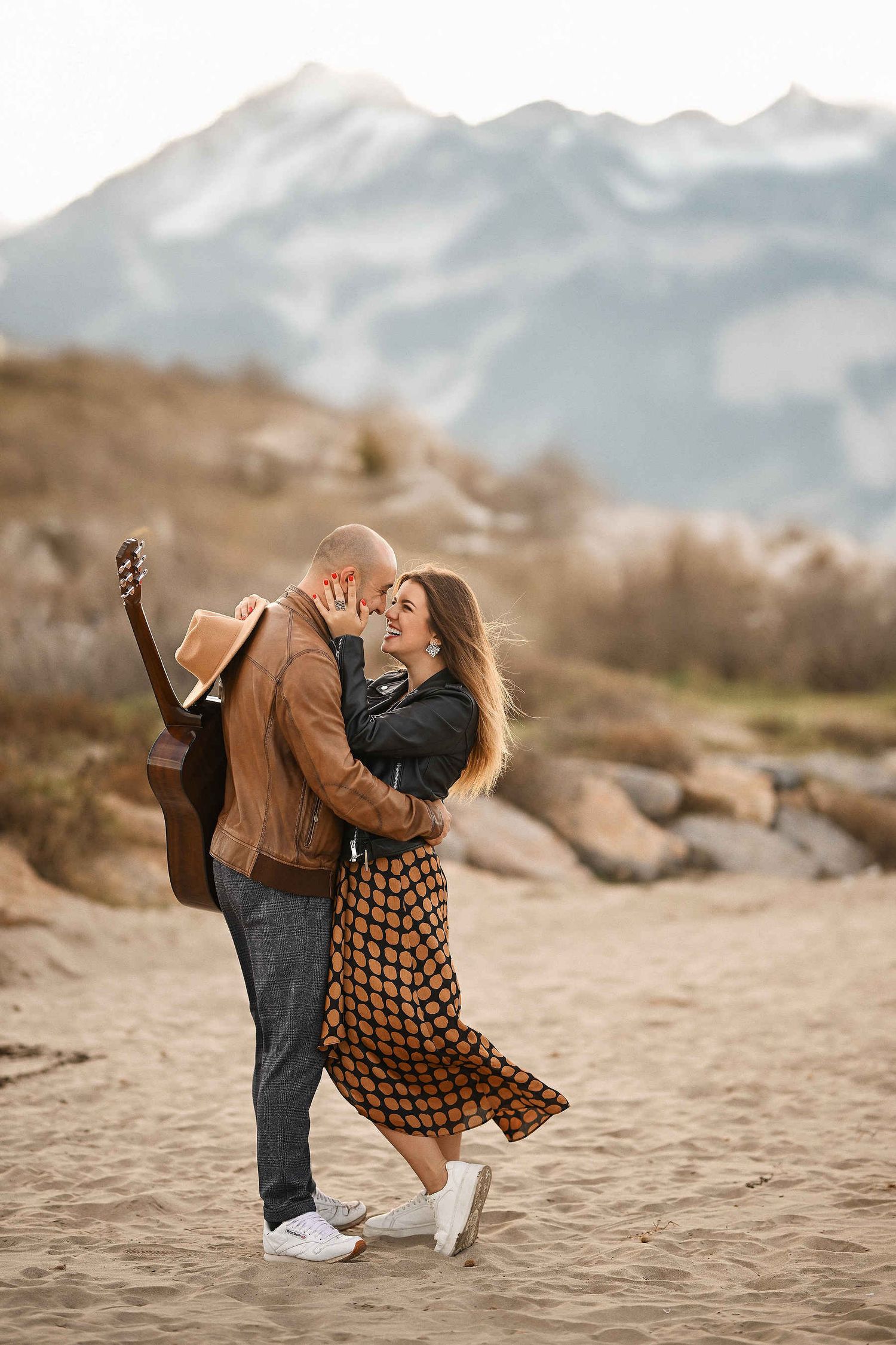 Couple spinning and dancing against the backdrop of mountains and the beach at El Saler dunes close to Valencia
