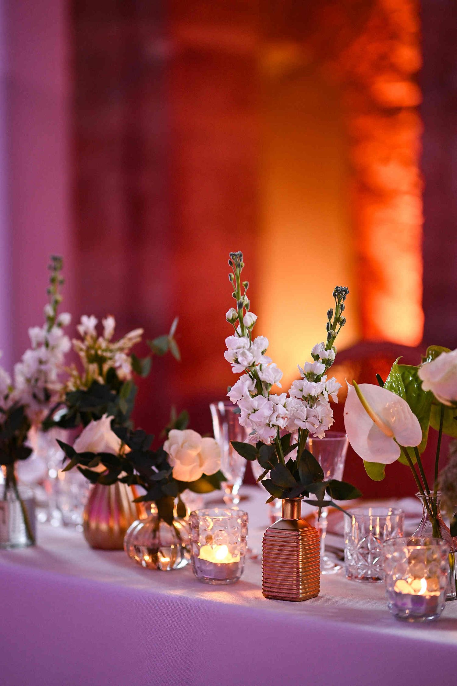 Sophisticated table setting and floral decor for a high-end wedding banquet at a historic Spanish monastery.