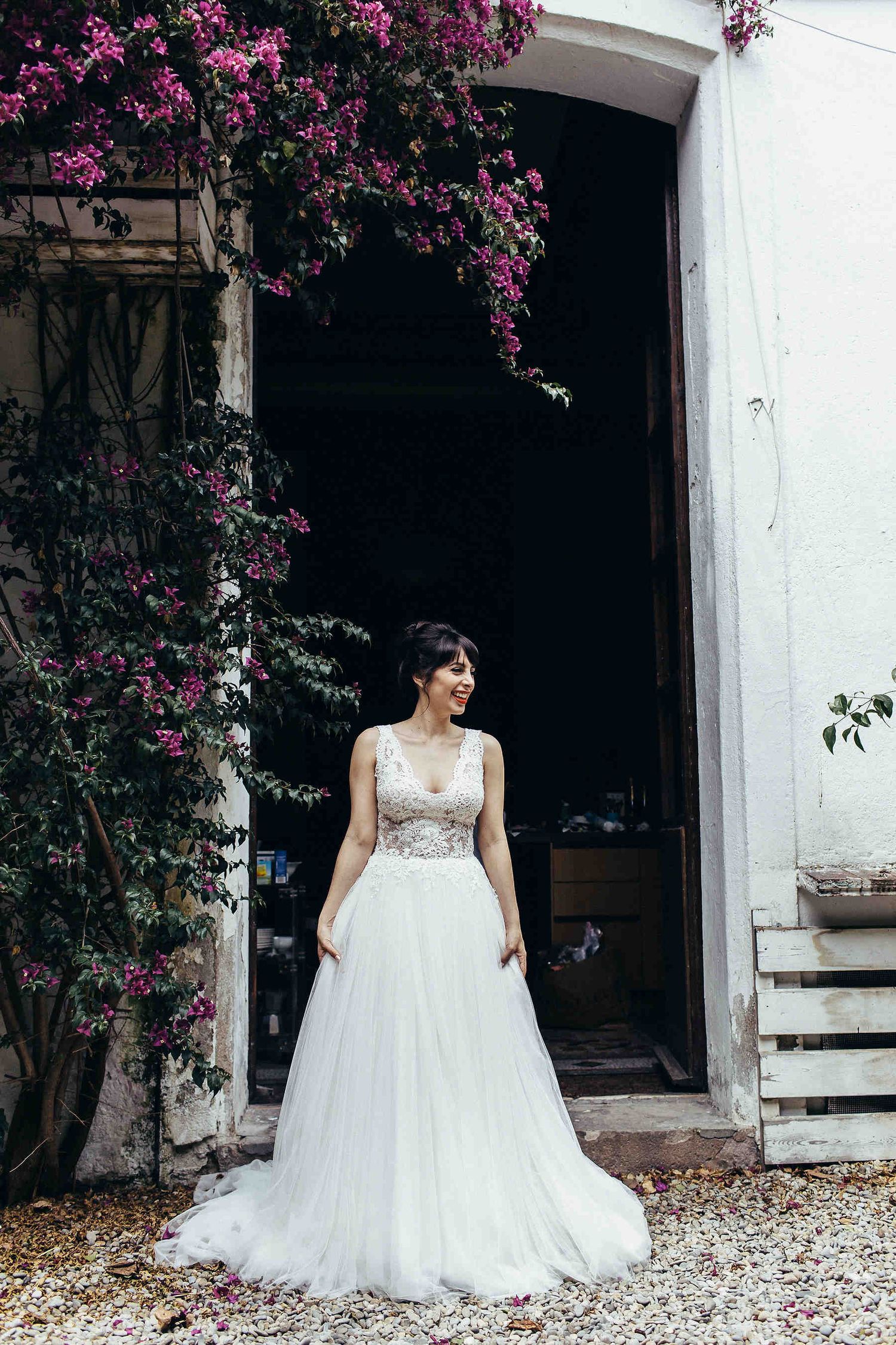 Full-length bride portrait in the villa courtyard featuring the dress train and a beautiful garden backdrop at Masia El Follo, Spain.