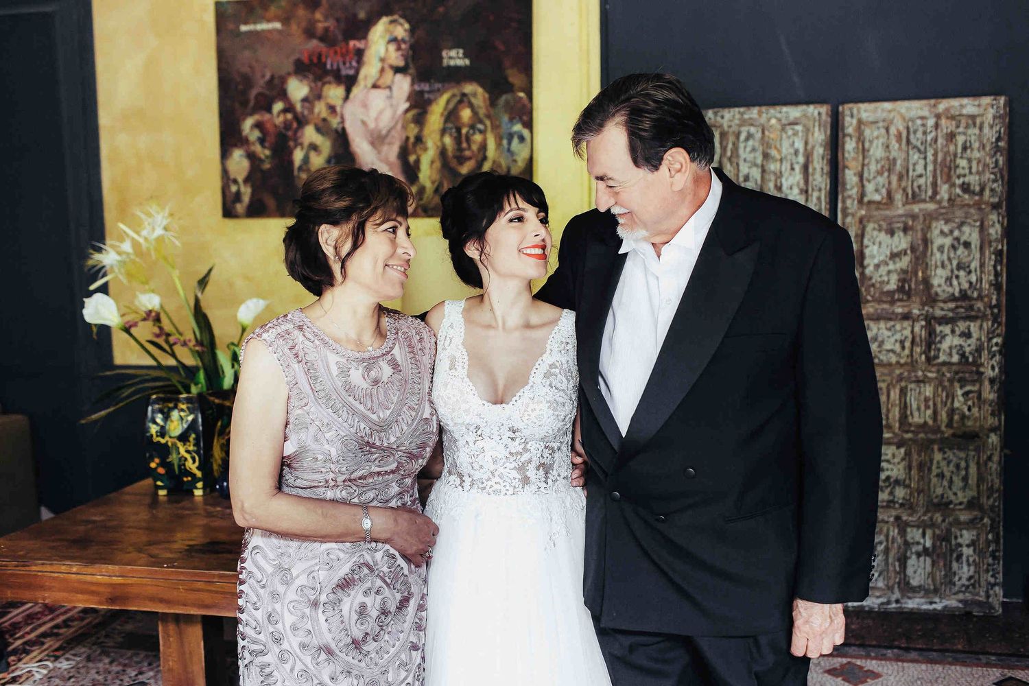 The bride posing with her mother and father at Masia El Follo. Timeless family wedding portrait captured in the heart of Catalonia, Spain.