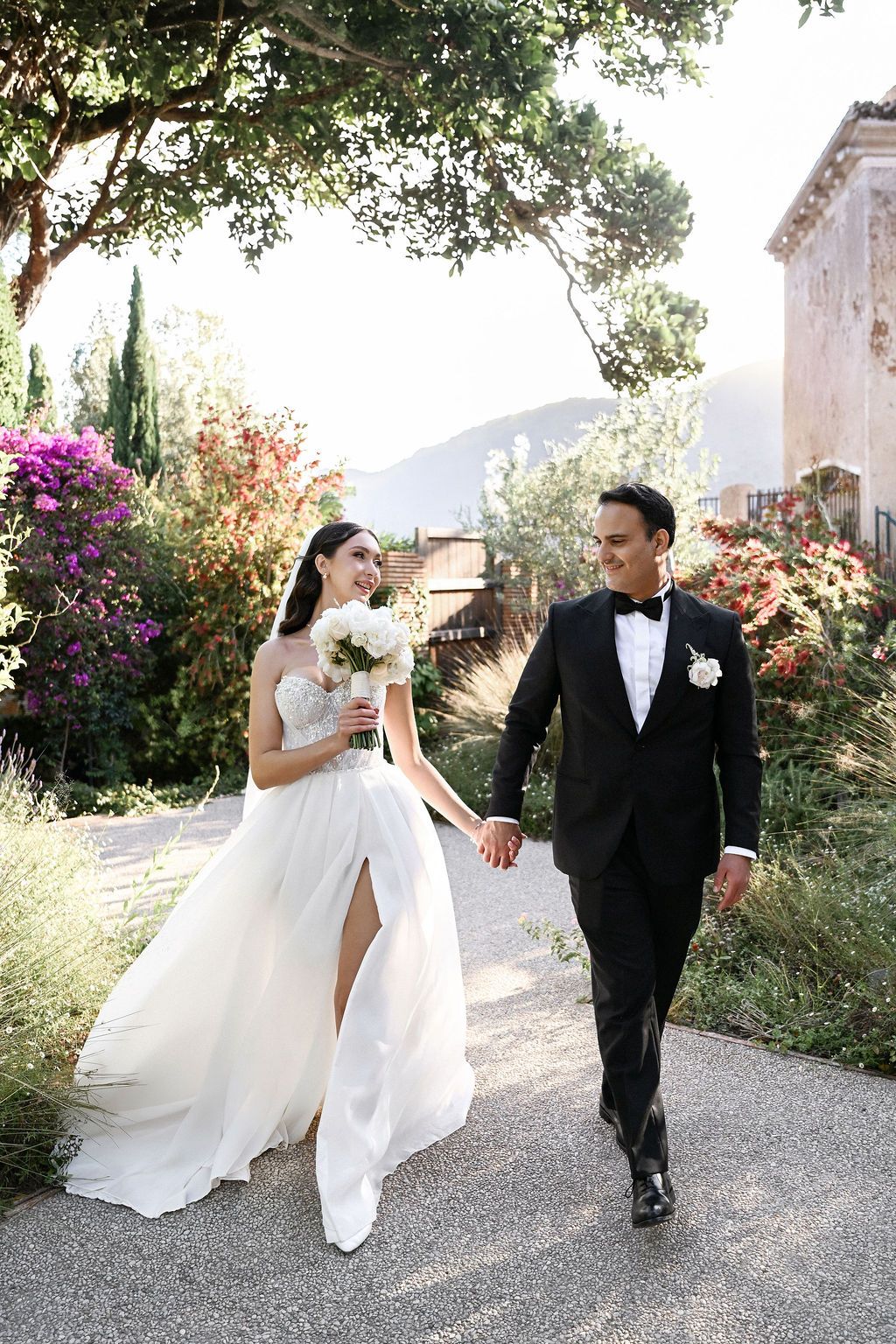 The couple walking through the estate gardens with a scenic view of the Spanish landscape, perfect for a dream destination wedding.