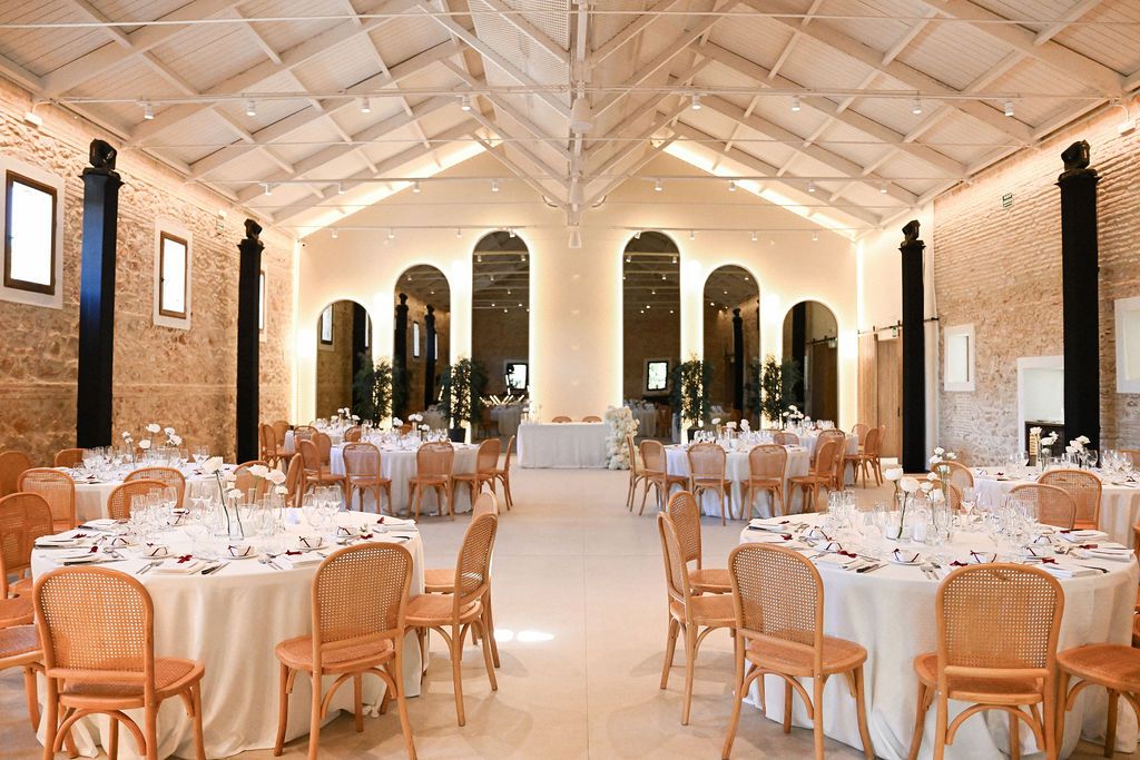 The beautifully styled dining hall at Finca del Canónigo with elegant table settings, captured before guests arrive for the wedding dinner.