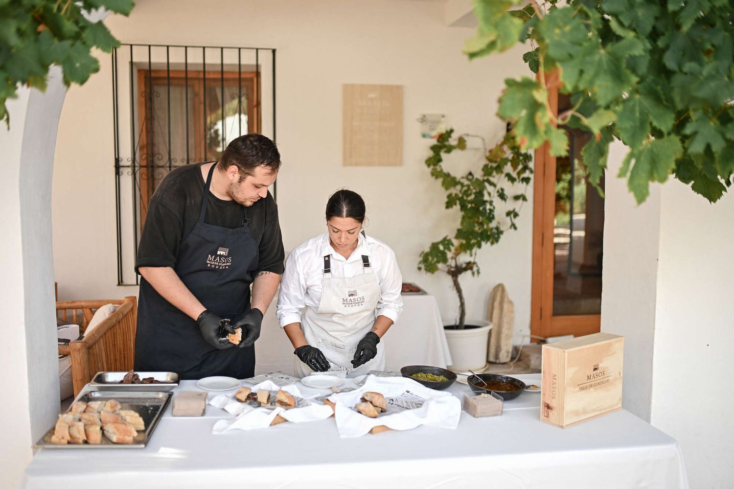 Catering staff in branded aprons preparing gourmet snacks during a wedding reception at Bodega MASOS