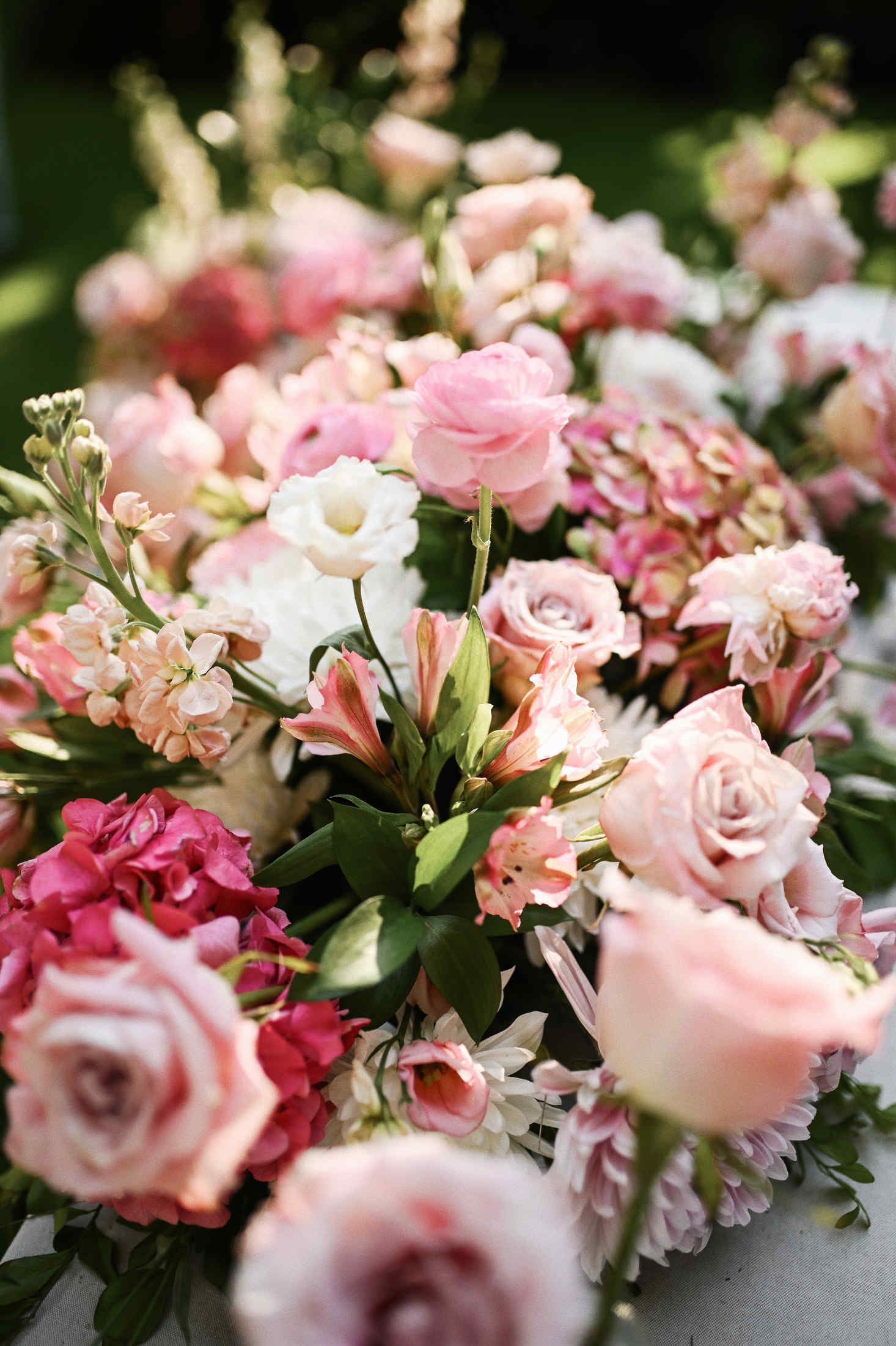 Elegant outdoor wedding table setup decorated with fresh blooming flowers for a reception dinner at Villa Dela.