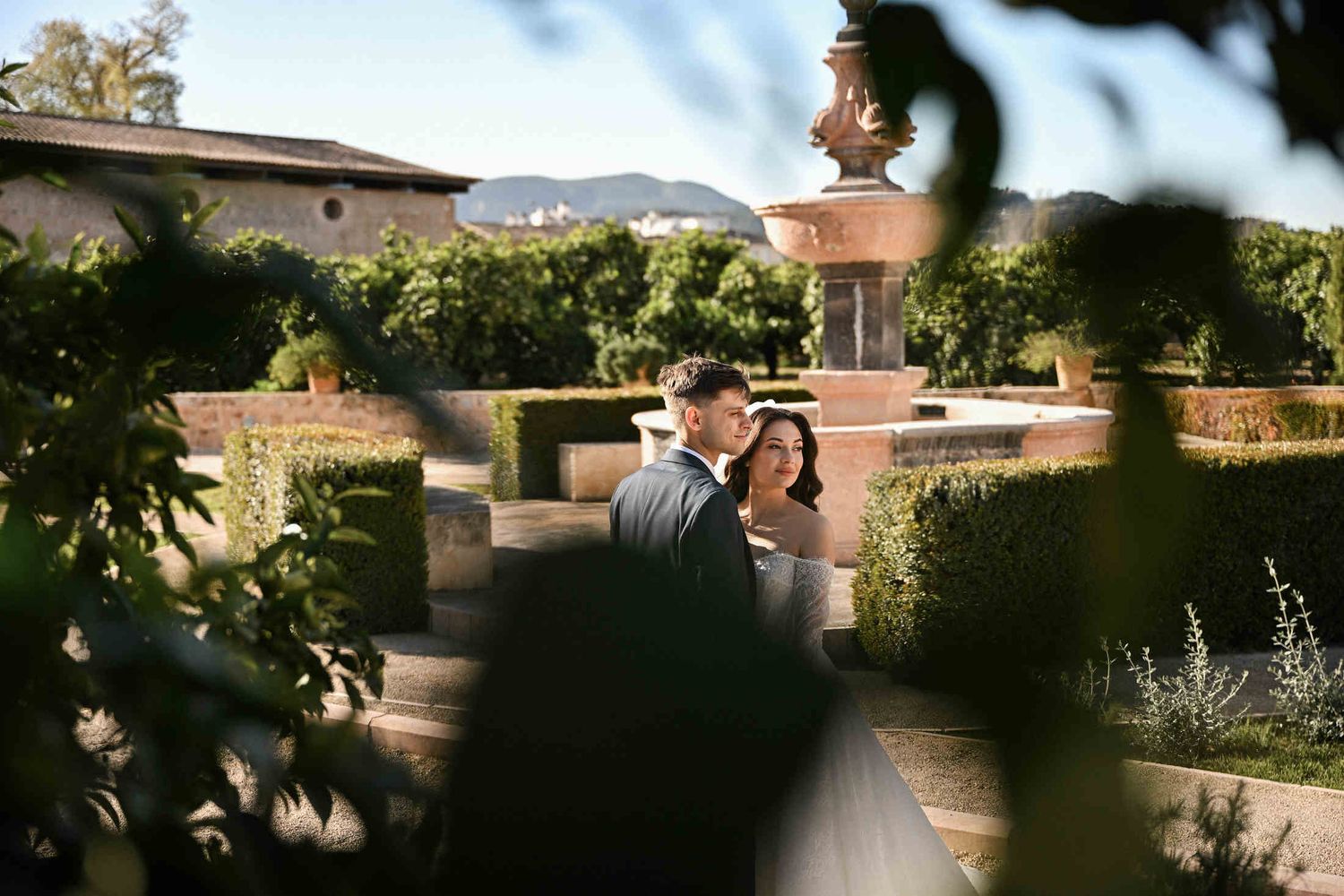 he couple amidst lush orange trees in the courtyard of Monasterio de Santa María de la Valldigna, reflecting authentic Spanish charm.